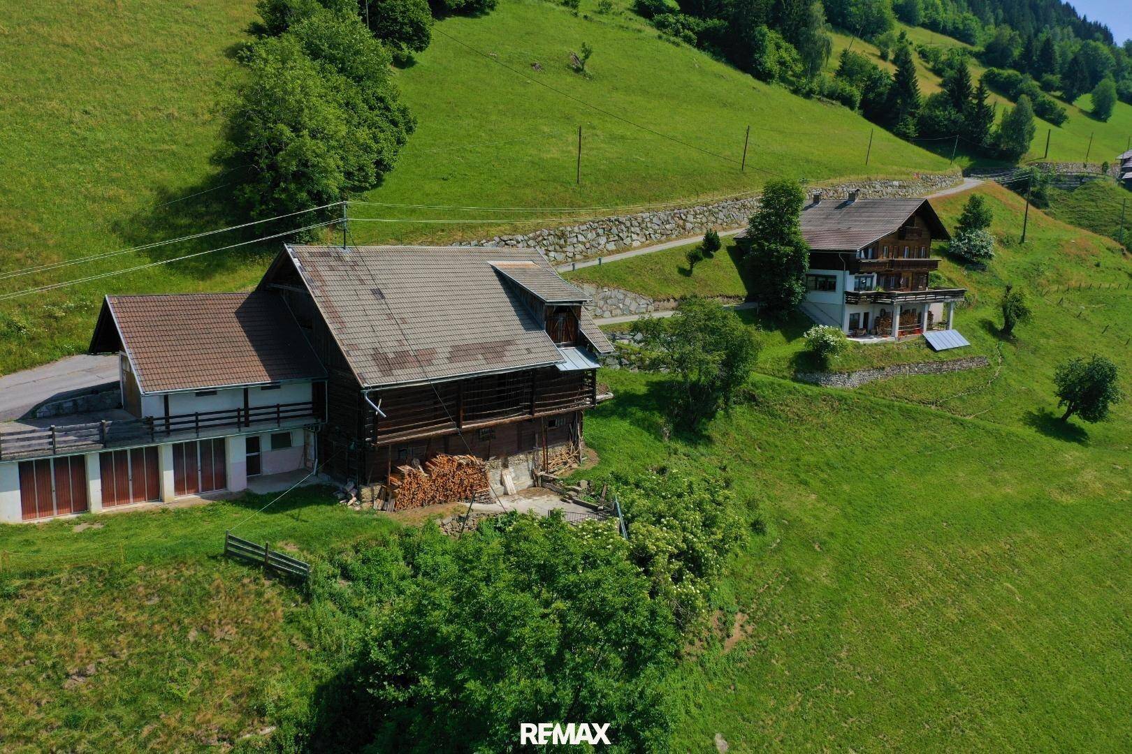 Luftaufnahme von zwei Gebäuden, einem Wohnhaus und einem Nebengebäude, in einer ländlichen Umgebung.