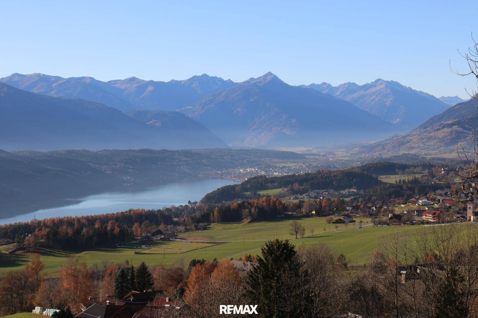Atemberaubender Panoramablick auf einen See, ein Tal und die umliegenden Berge in herbstlicher Pracht.