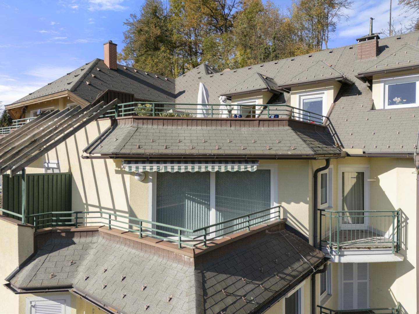 Detailansicht der Gebäudefassade mit mehreren Balkonen und Dachstrukturen.