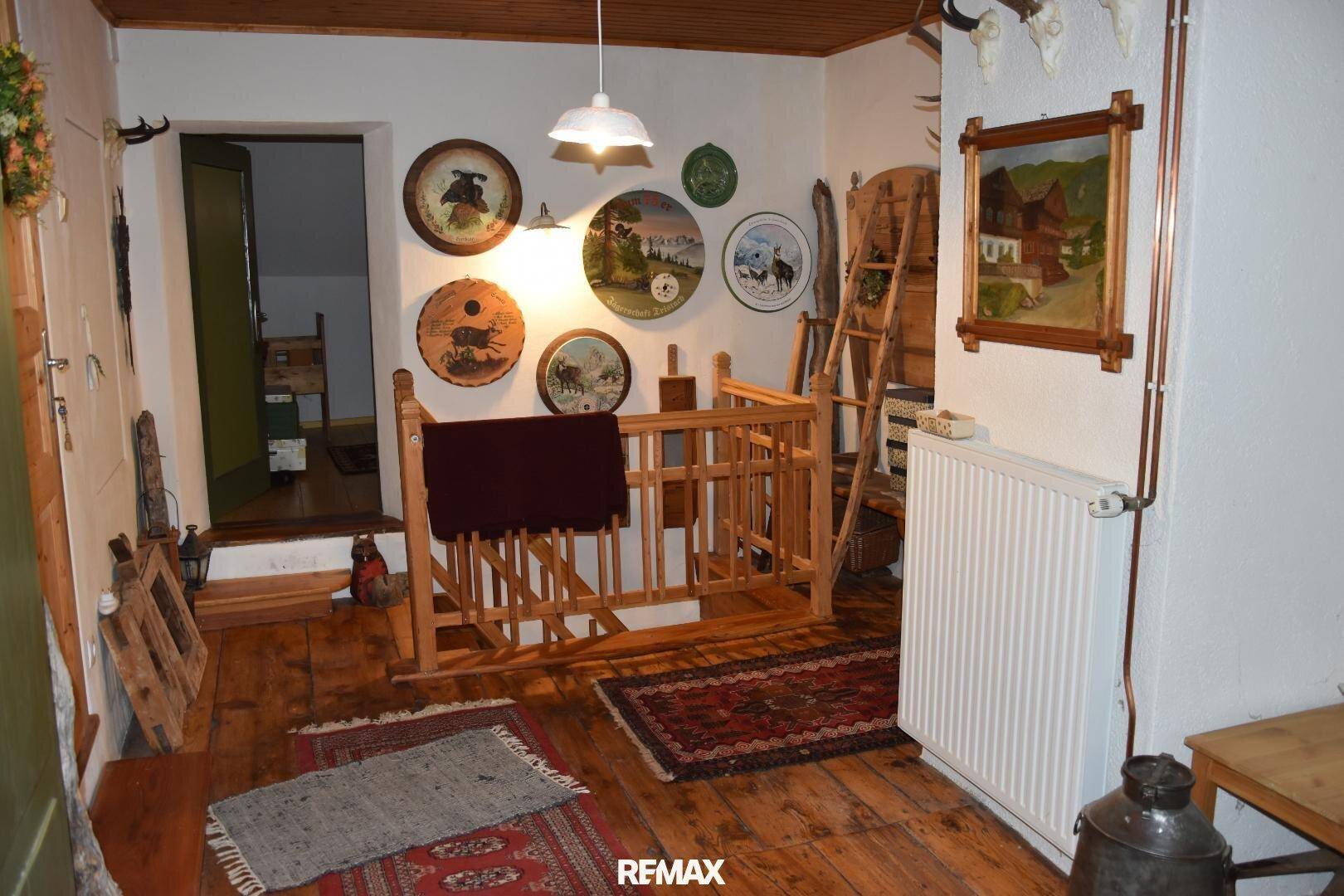 Oberer Flurbereich mit Holzboden, Geländer und traditionellen Wanddekorationen.