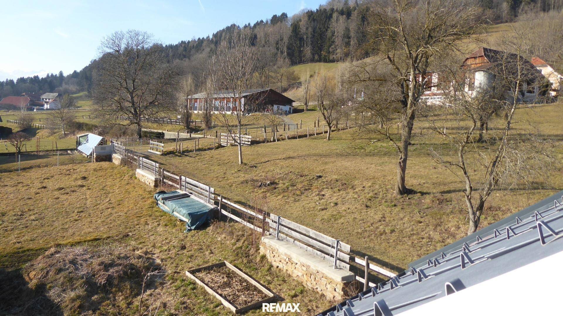 Weitläufige ländliche Umgebung des Anwesens mit Feldern, Bäumen und Nachbarhäusern.