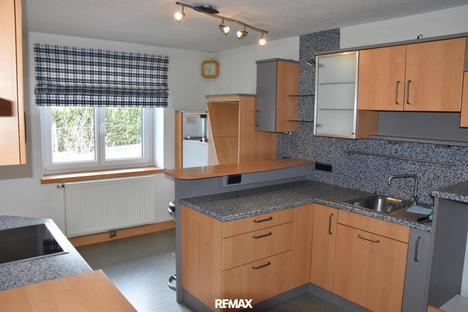 Moderne Küche mit Holz- und grauen Fronten, Granitarbeitsplatte und Frühstücksbar.
