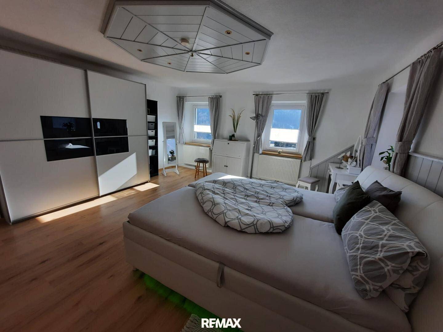 Gemütliches Schlafzimmer mit Doppelbett, großem Kleiderschrank und Laminatboden.