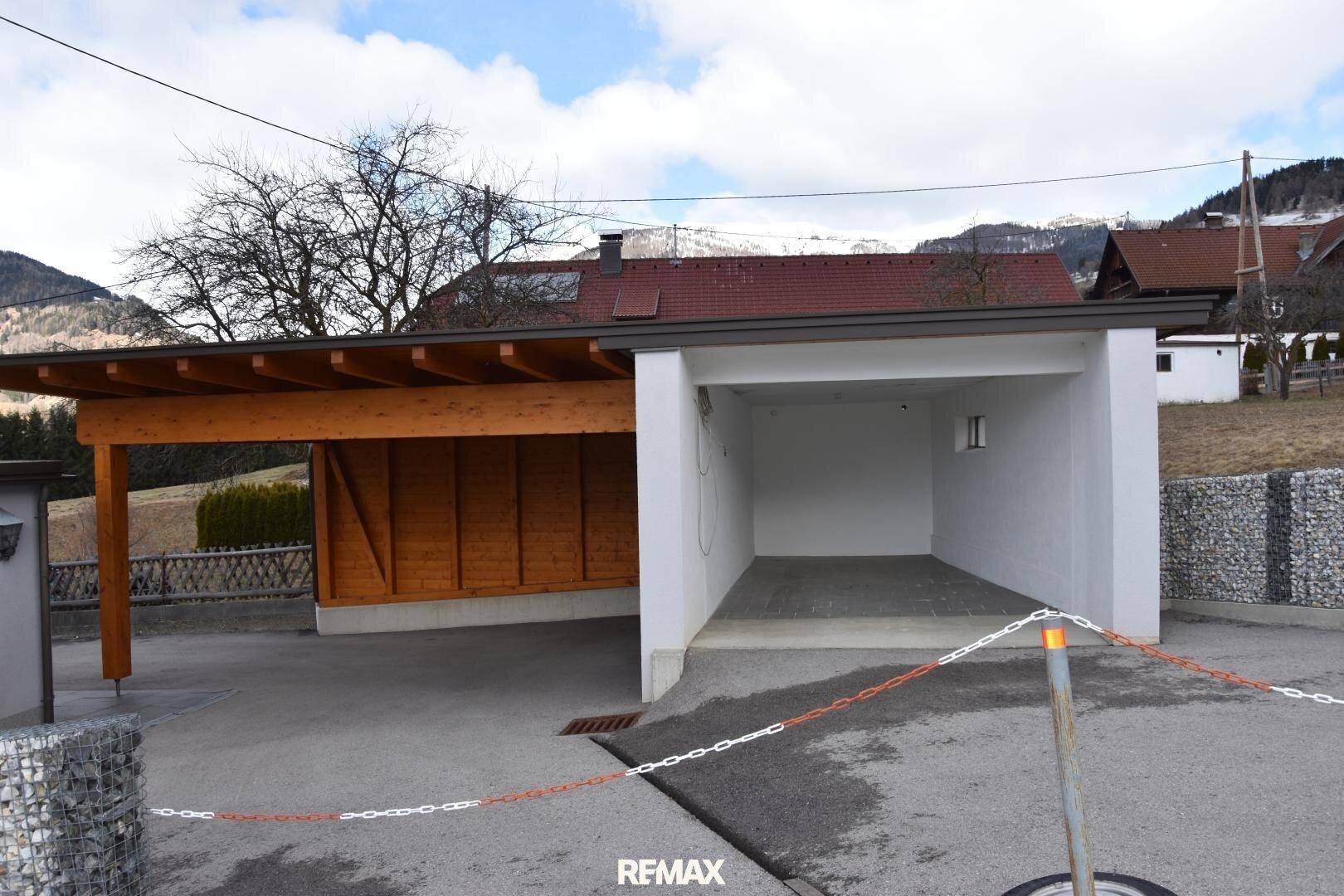 Überdachter Carport und Garagenbereich neben dem Haus mit Blick auf die Berge.