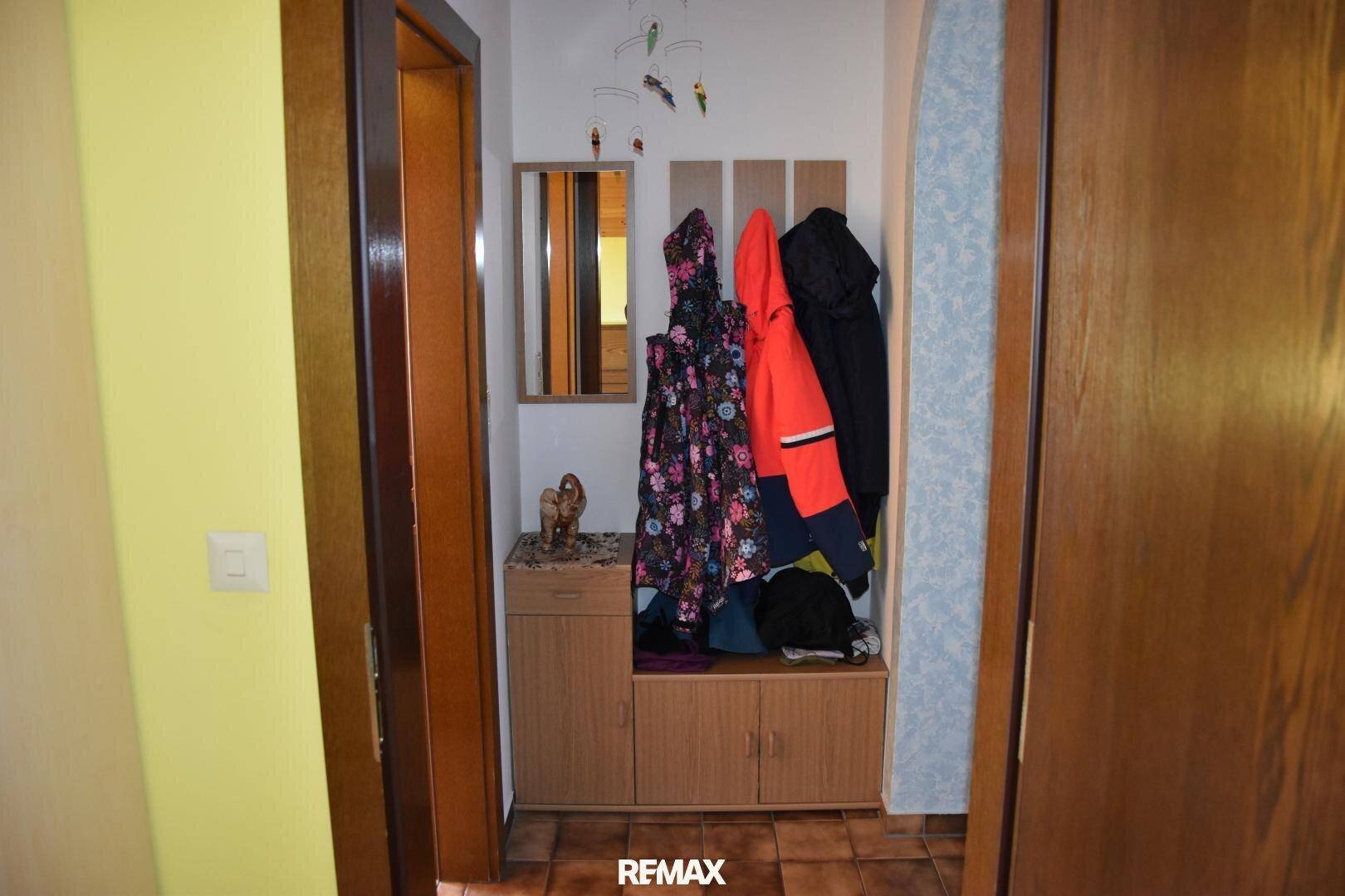 Eingangsbereich mit Garderobe, Spiegel und Fliesenboden, praktisch und einladend.