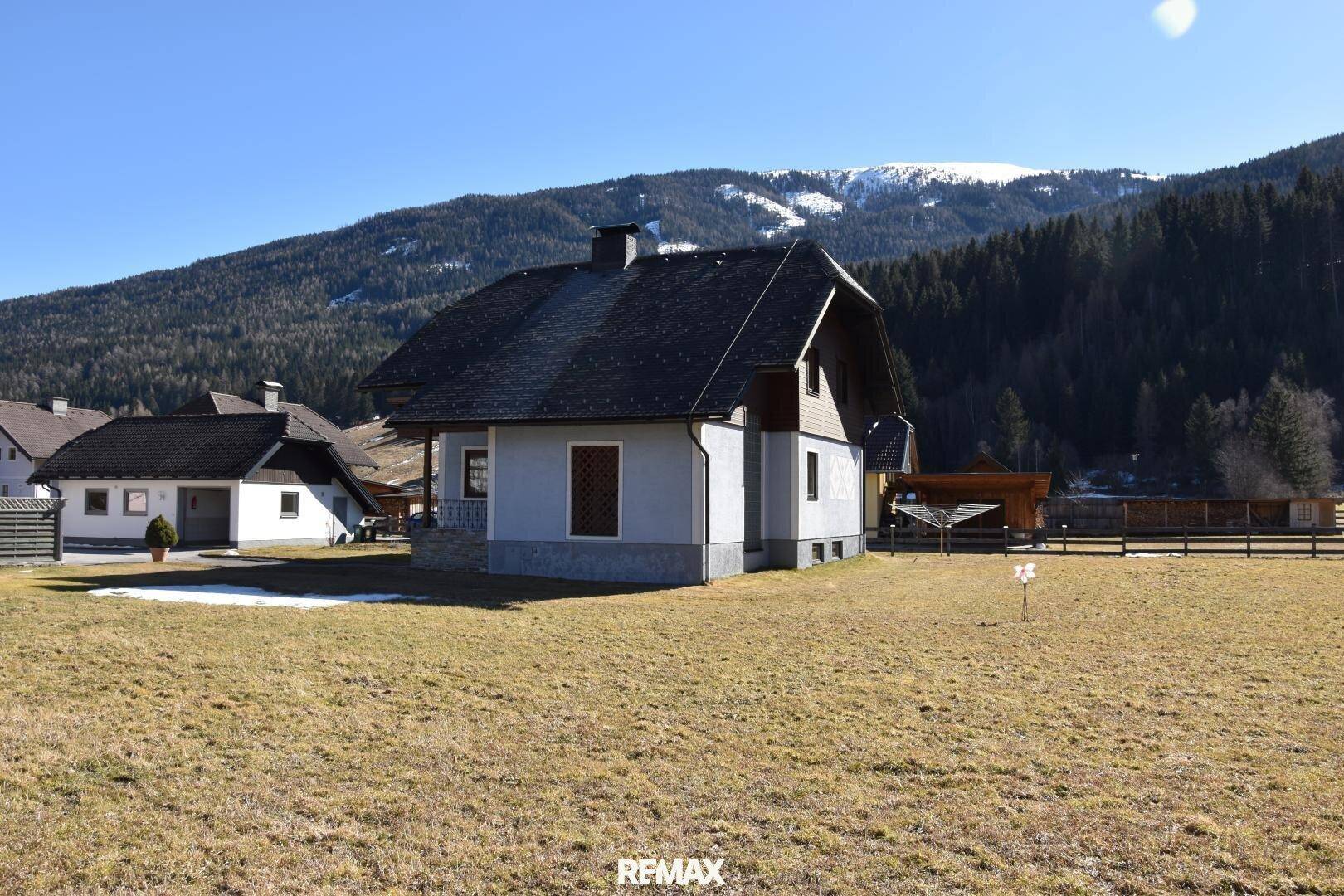 Freistehendes Haus mit Satteldach und weitem Blick auf die umliegende Berglandschaft und Wiesen.