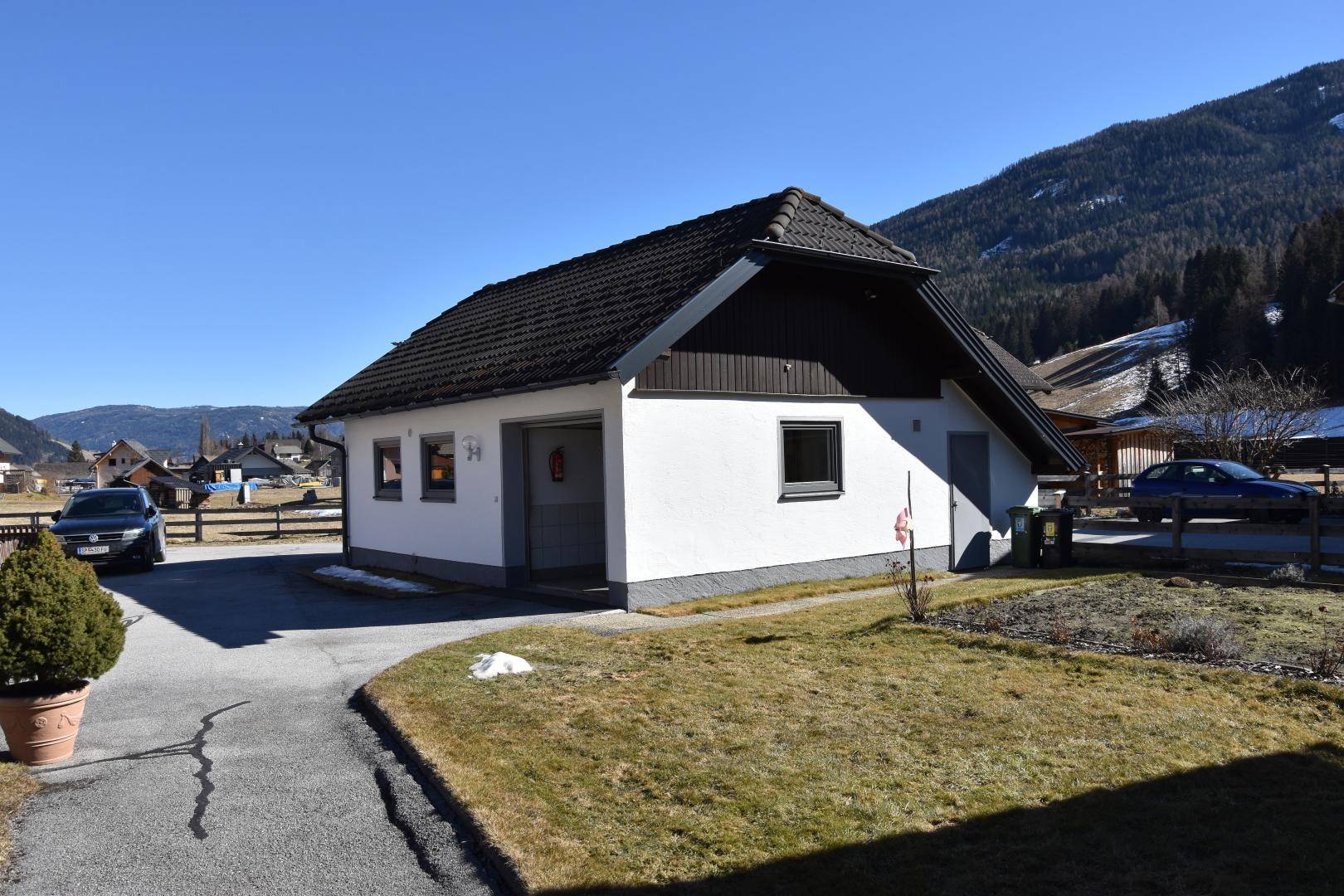 Separates Garagengebäude mit Zufahrt und Rasenfläche in ländlicher Umgebung.