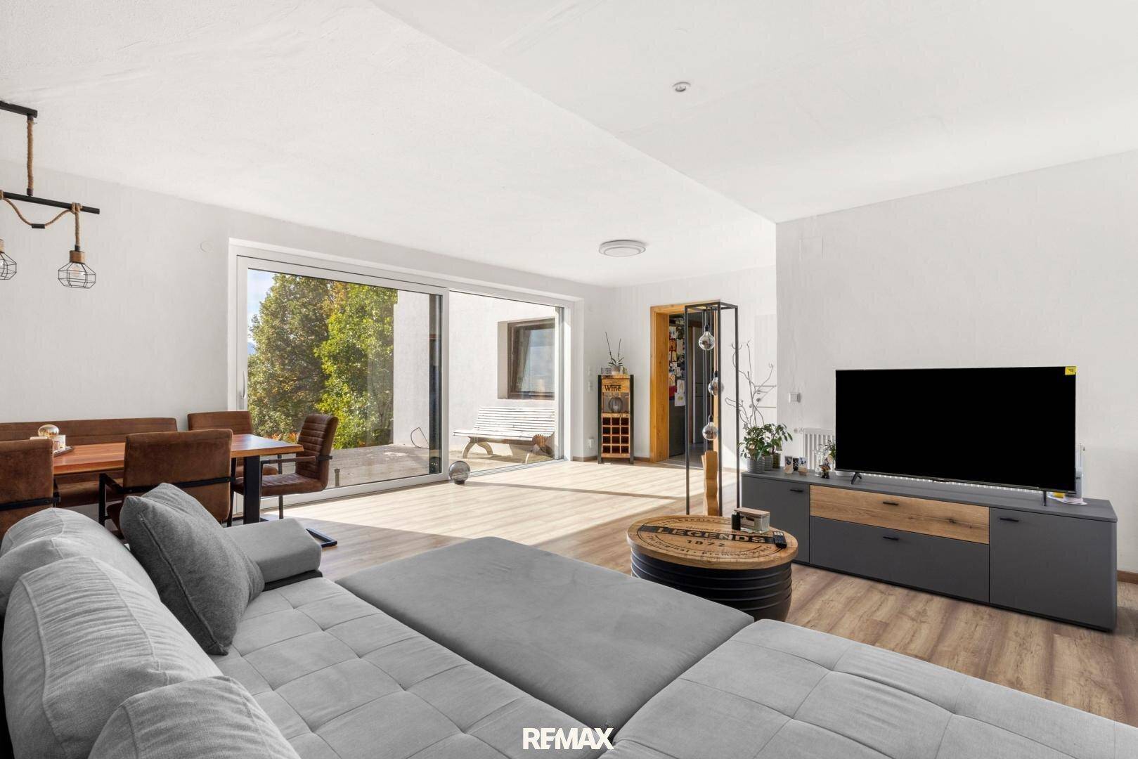 Großzügiger Wohn- und Essbereich mit großen Schiebetüren zur Terrasse und modernem Interieur.