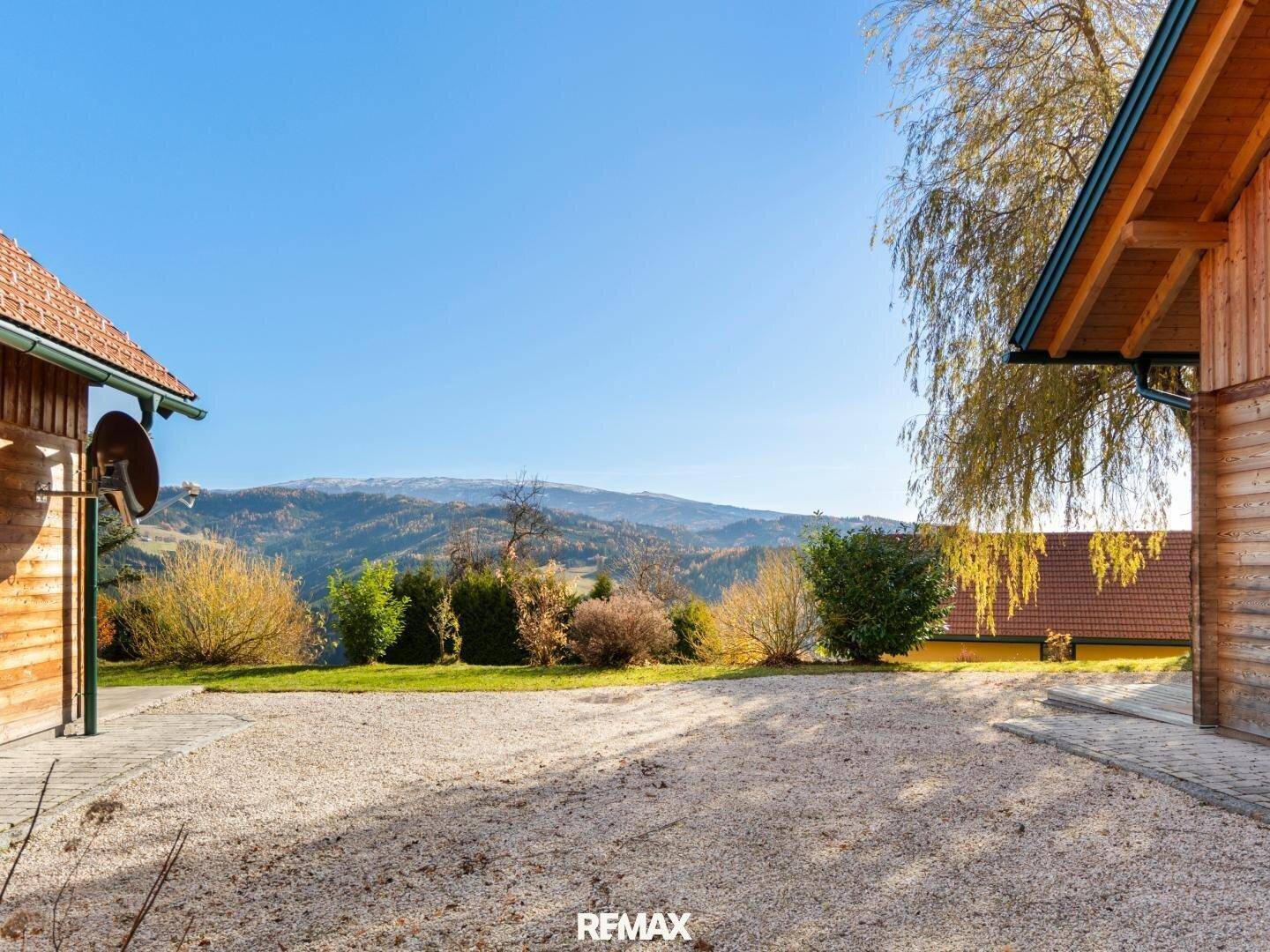 Kiesfläche zwischen den Gebäuden mit weitem Blick auf die umliegende Berglandschaft.