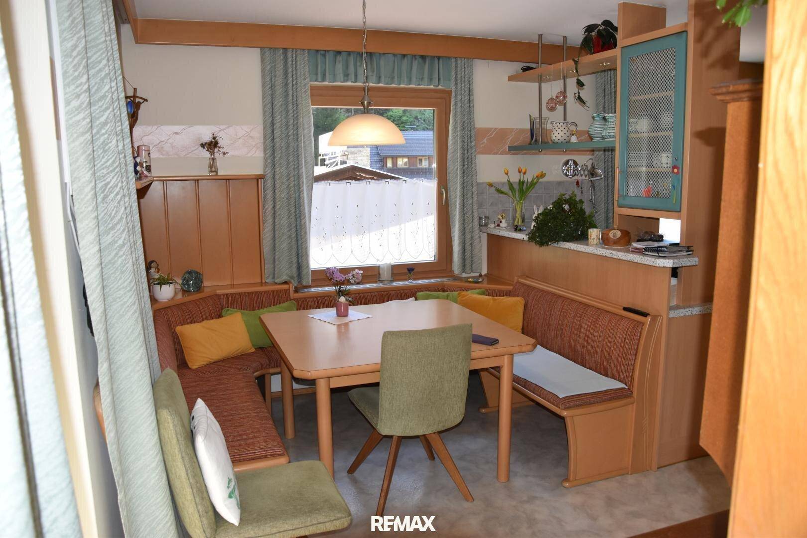 Essbereich mit Holztisch, eingebauter Sitzbank und einem Fenster, das für Helligkeit sorgt.
