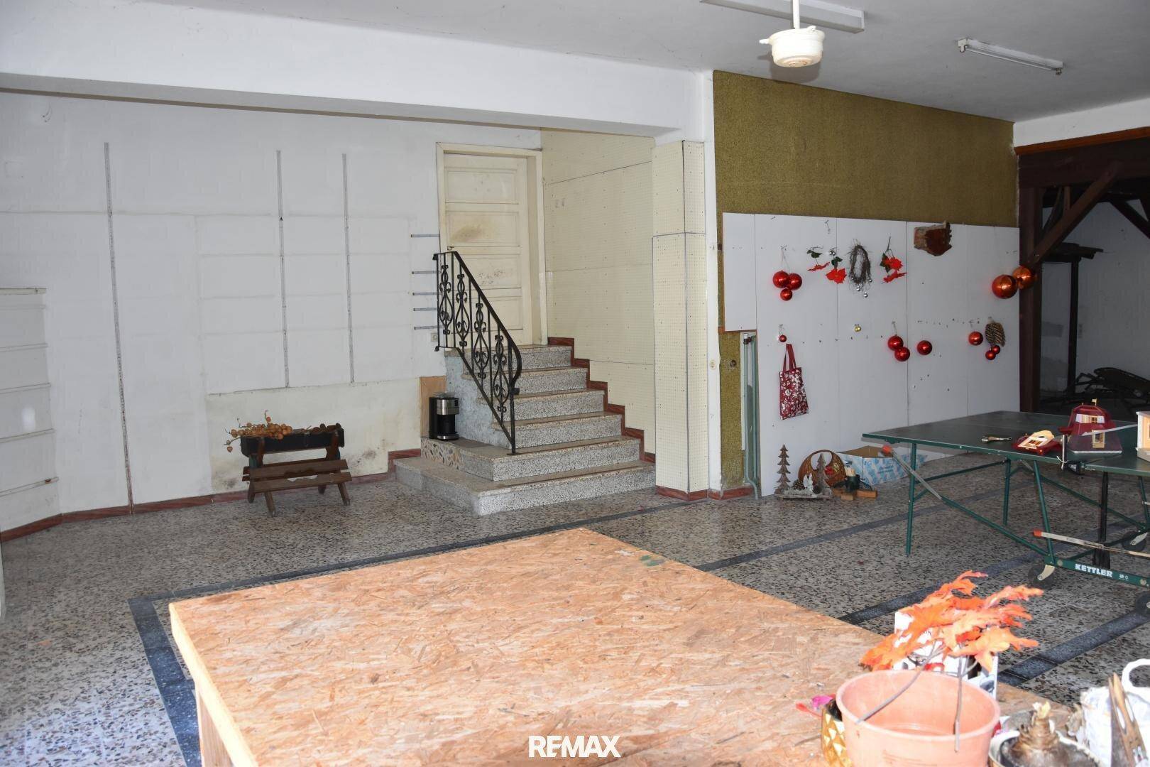 Weiterer Blick in den großen Untergeschossraum mit Treppe und viel Platz.