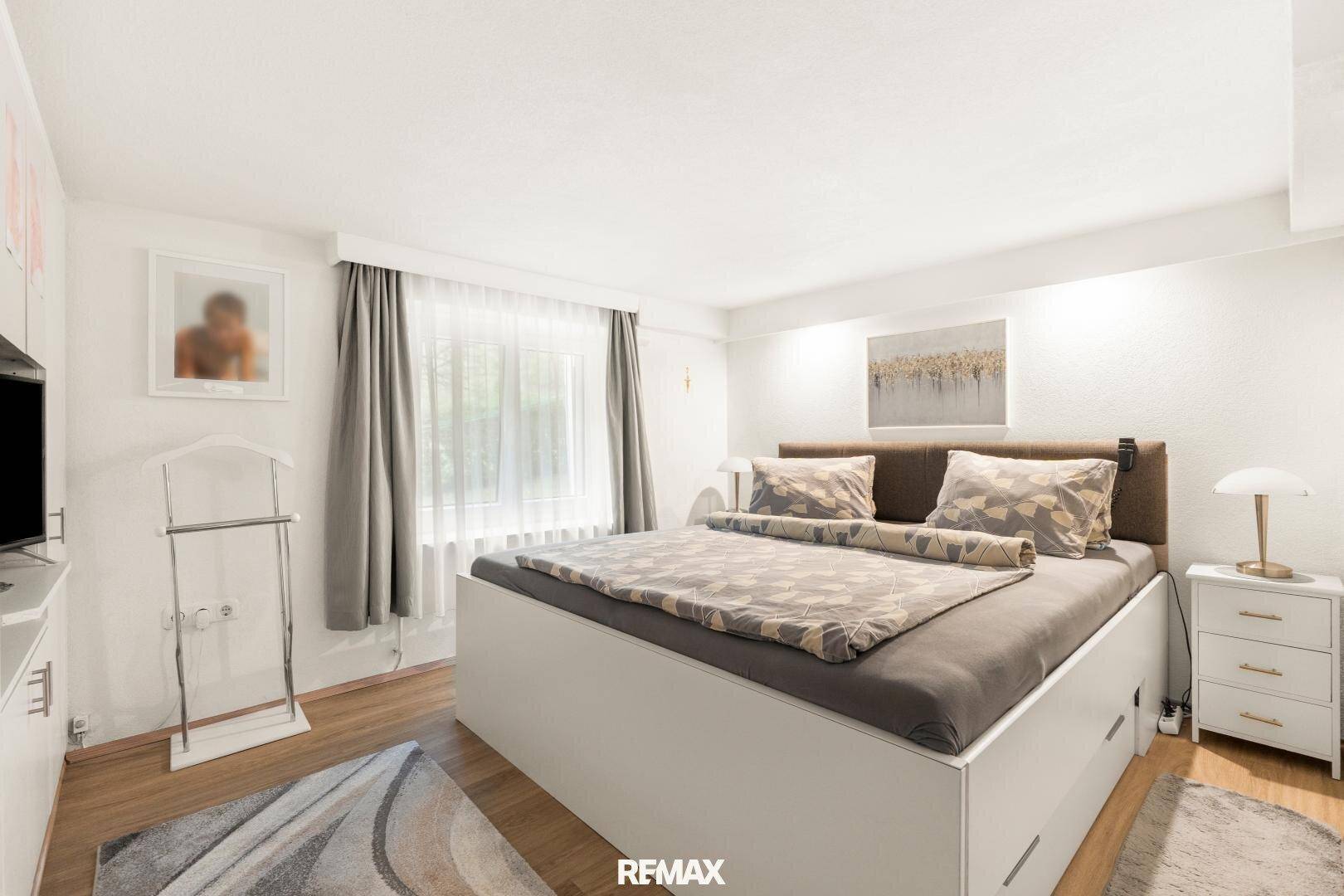 Modernes Schlafzimmer mit großem Bett, weißen Möbeln und Fenster für Tageslicht.