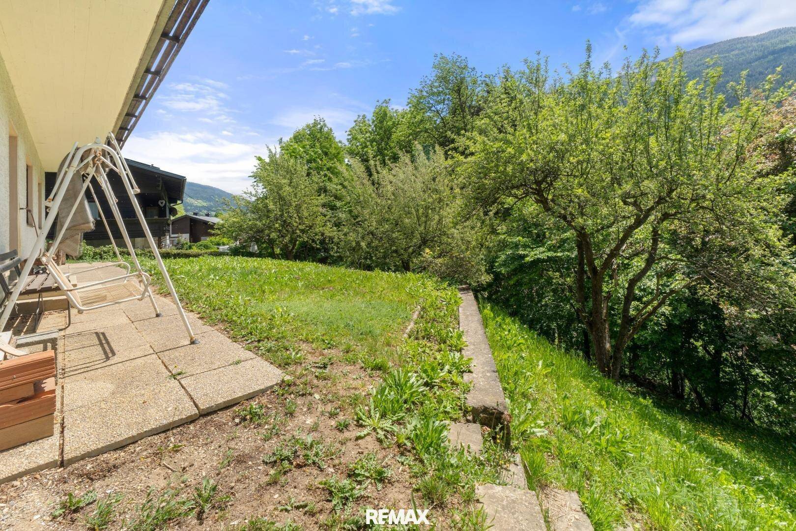 Garten mit Rasenfläche und Schaukel, ideal für Entspannung im Freien.