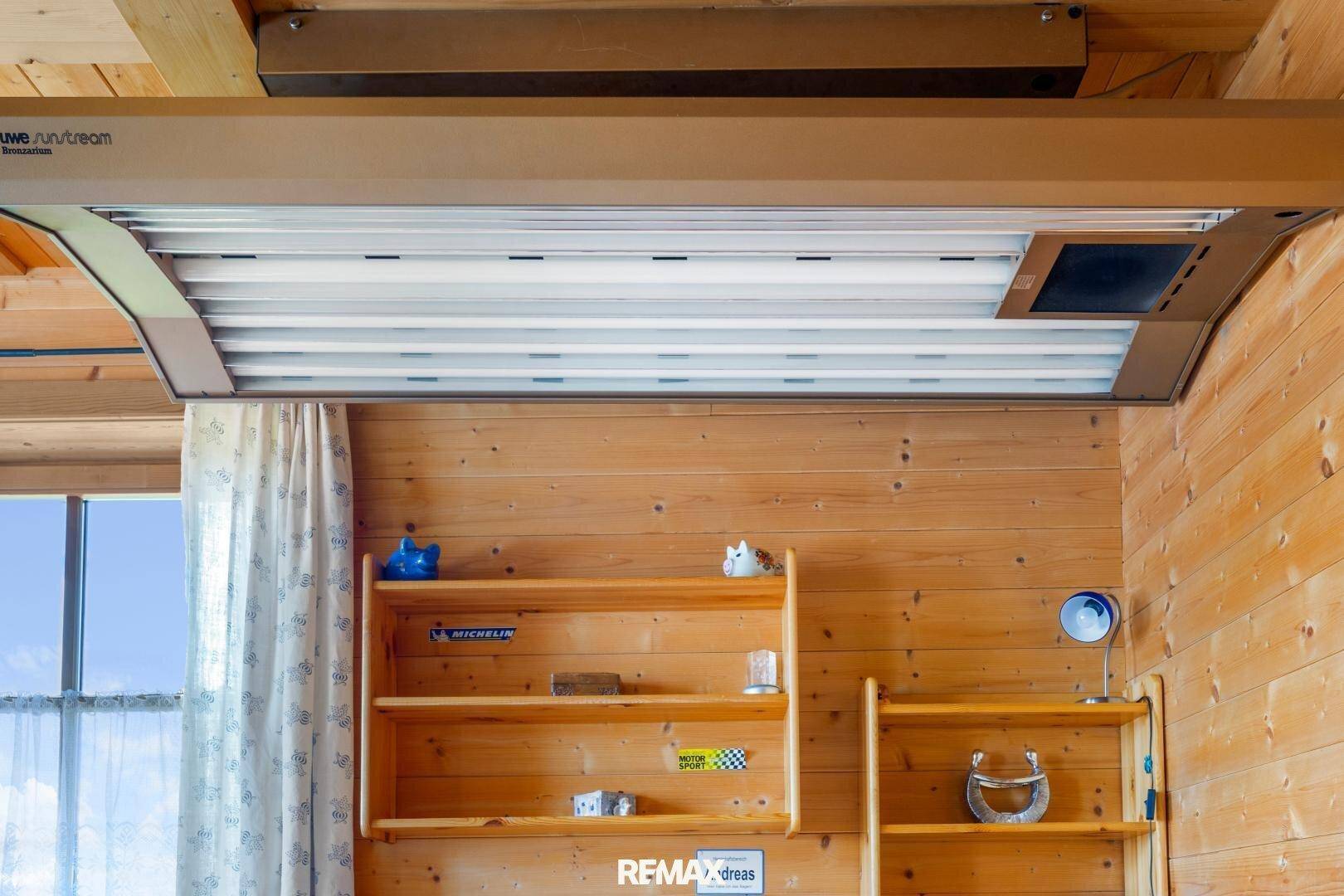 Zimmer mit Holzwänden und einem Solarium an der Decke.