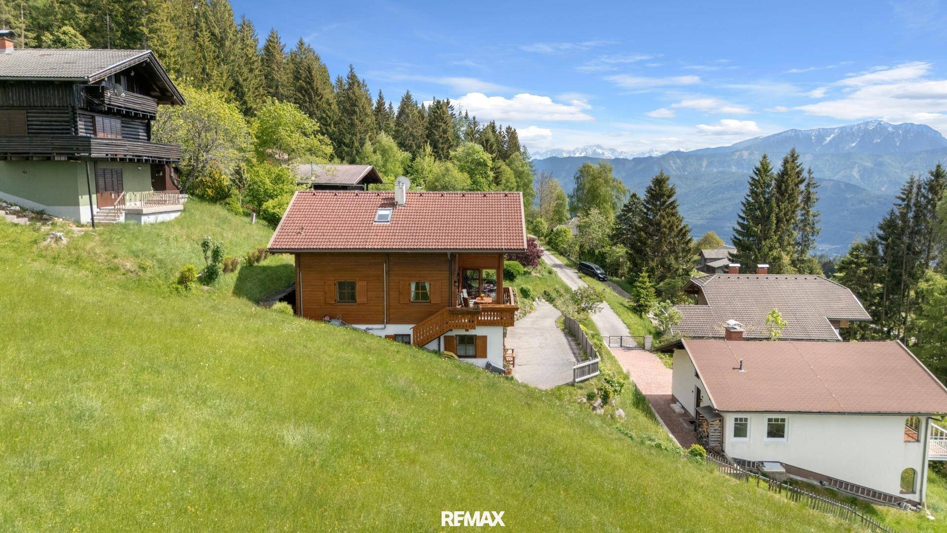 Charmantes Holzhaus in Hanglage mit Bergblick und umliegender Natur.
