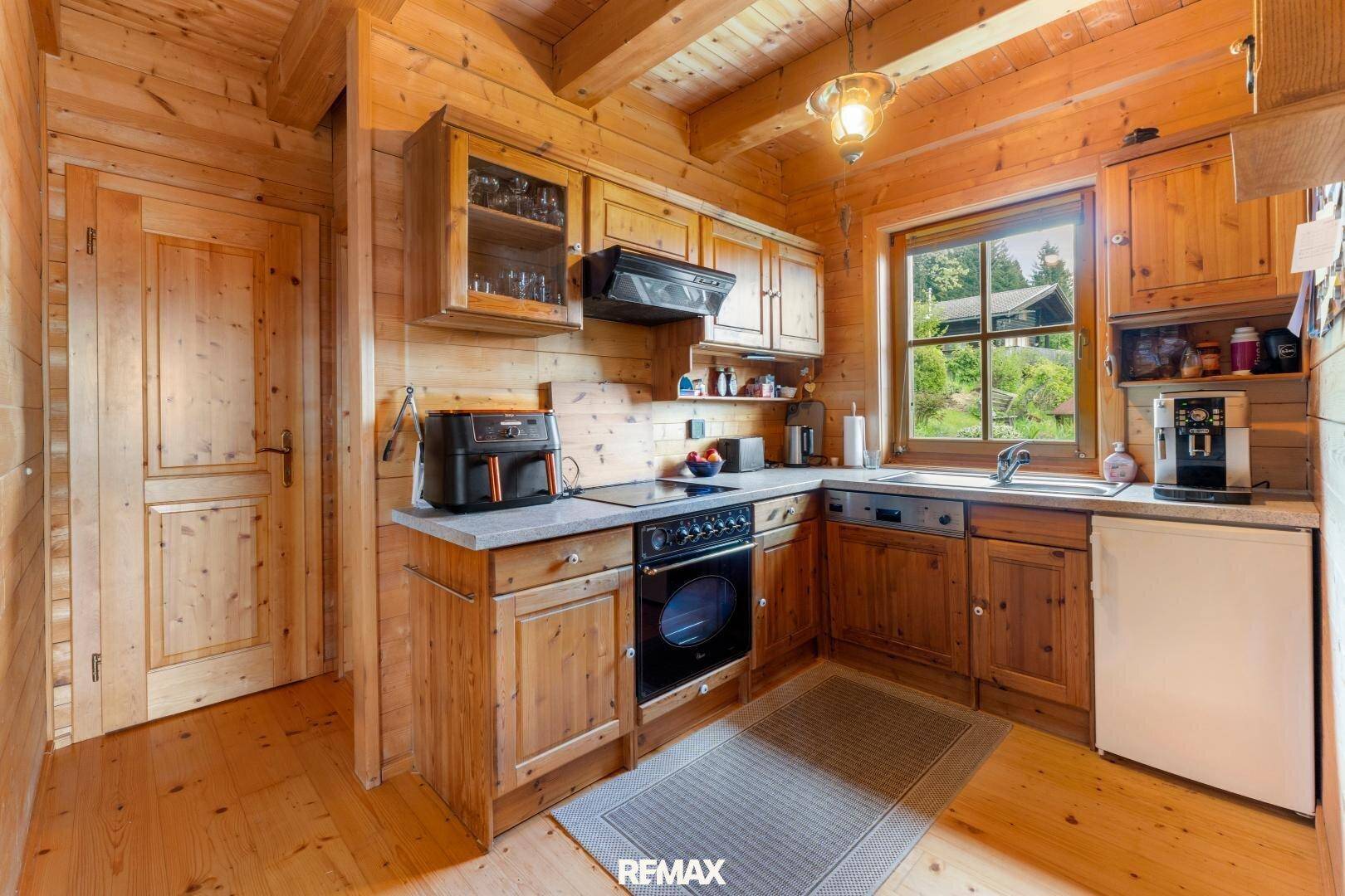 Funktionale Holzküche mit Einbaugeräten, Fenster und traditionellem Design.