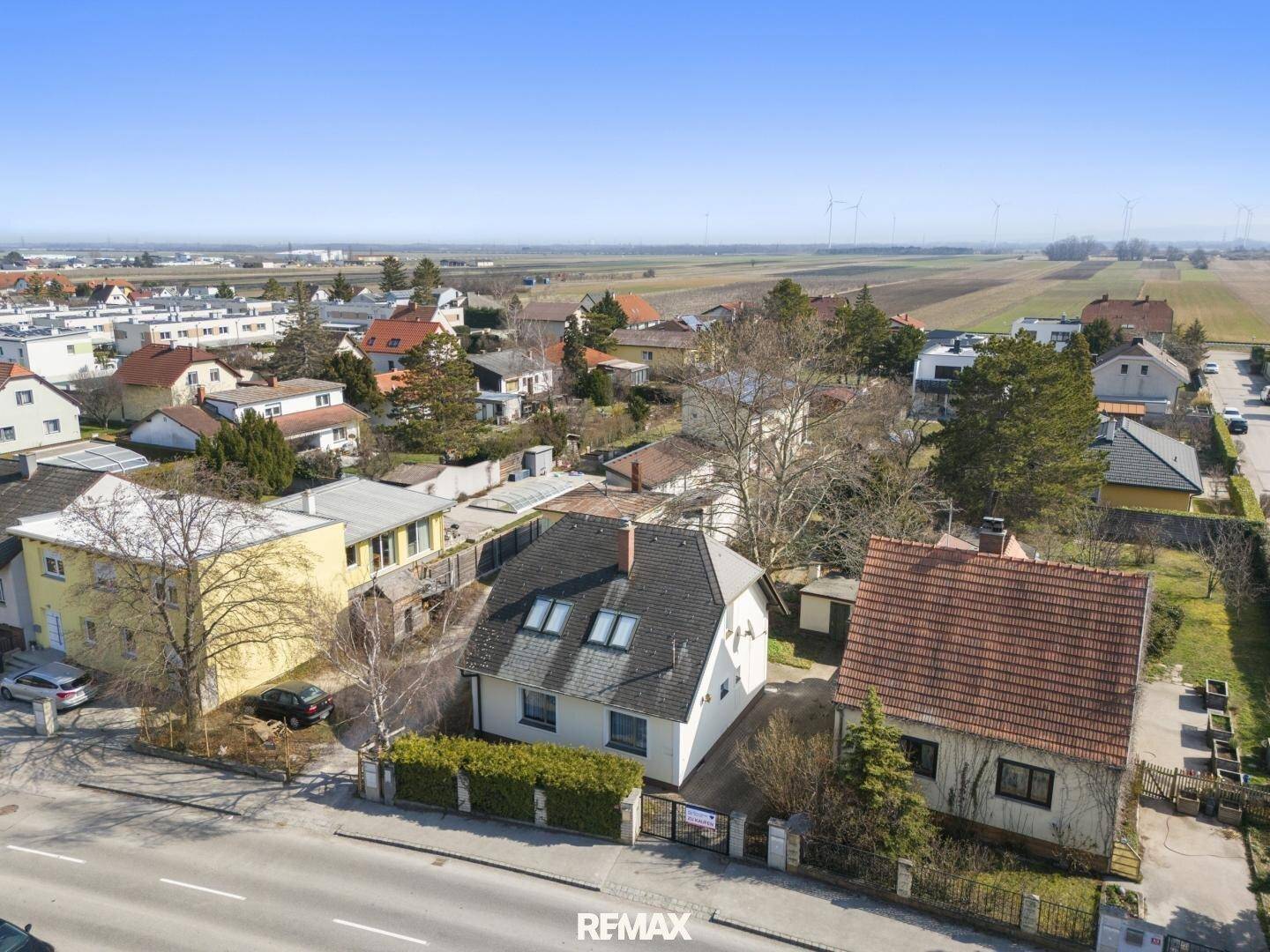 Vogelperspektive des Hauses und der umliegenden Nachbarschaft mit weiten Feldern im Hintergrund.