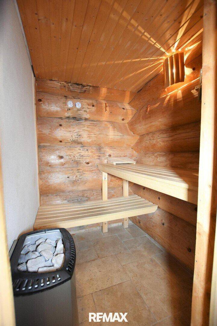 Gemütliche Holzsauna mit Bänken und Saunaofen für entspannende Wellnessmomente.