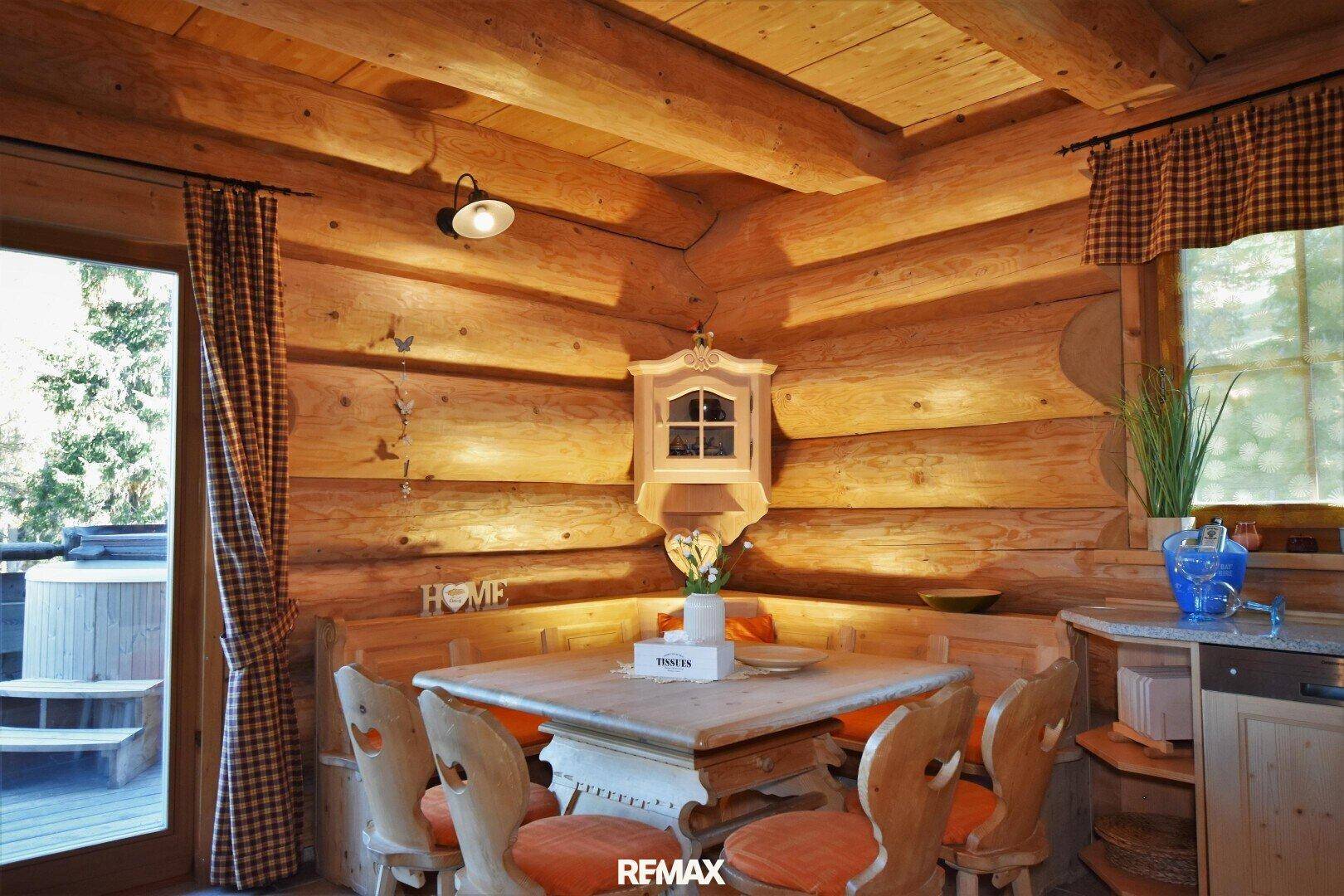 Essbereich im Chalet-Stil mit Holzbänken, Esstisch und Zugang zu einem Außen-Whirlpool.
