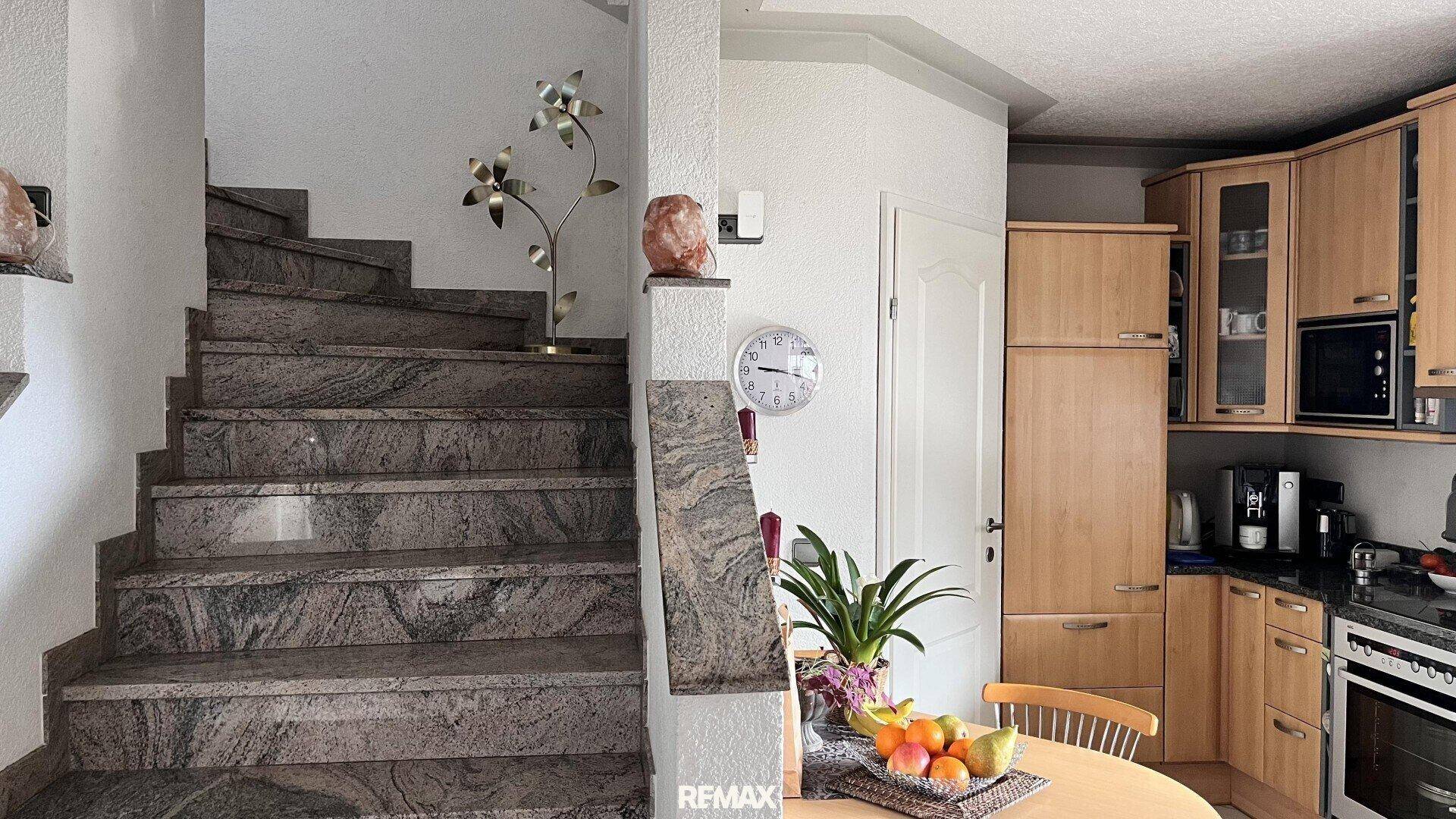 Treppenaufgang mit Granitstufen und Geländer, angrenzend an die Küche und den Essbereich.