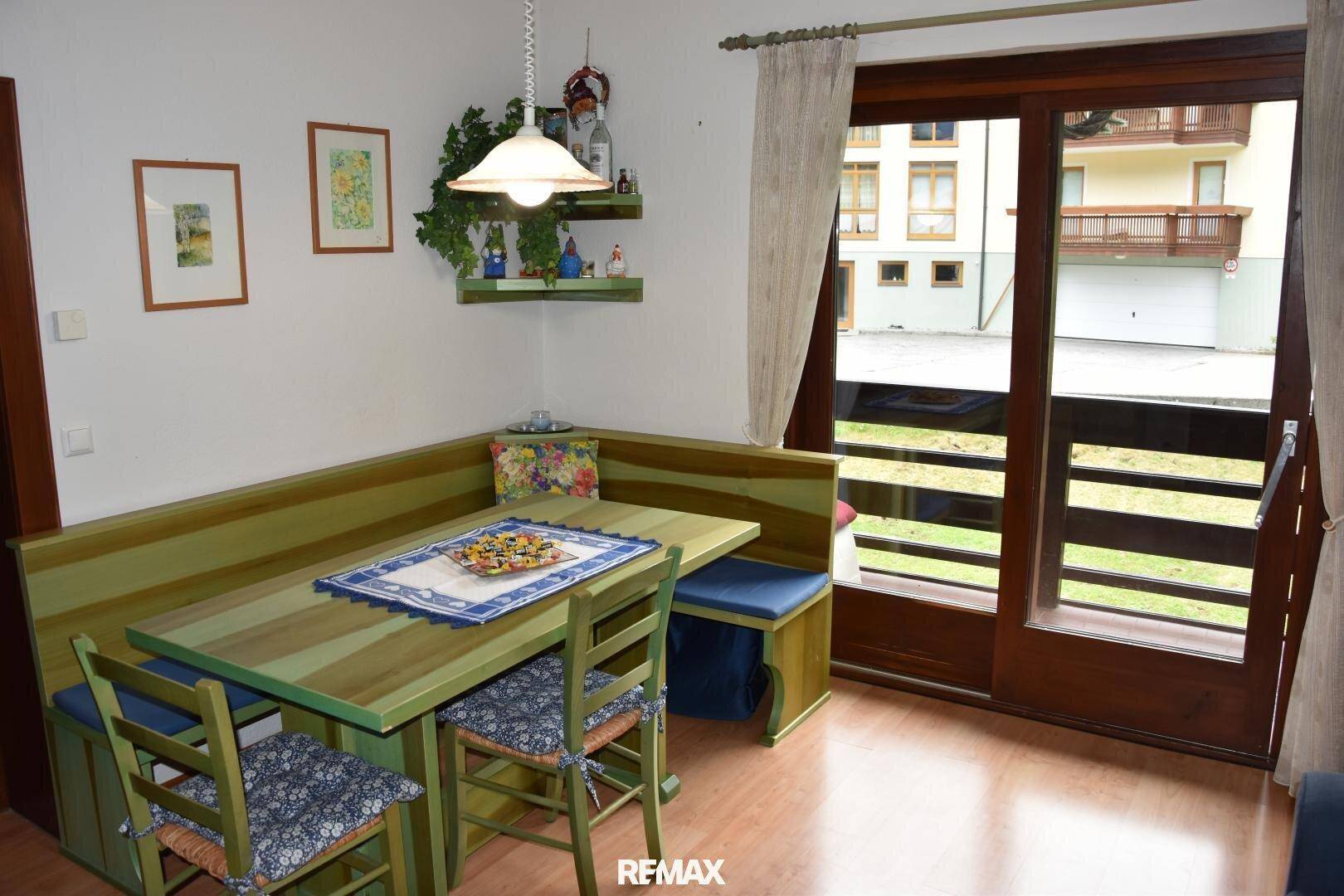 Essbereich mit rustikaler Eckbank und Holztisch, direktem Zugang zum Balkon.