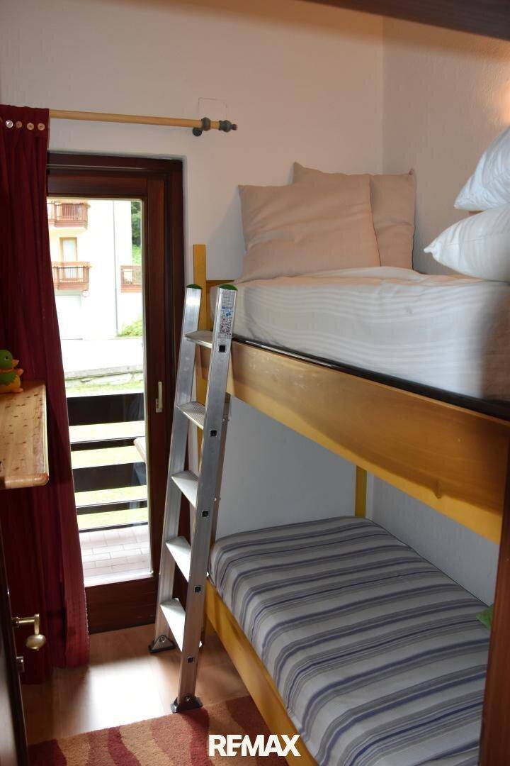 Kinder- oder Gästezimmer mit Etagenbett und direktem Zugang zu einem Balkon.