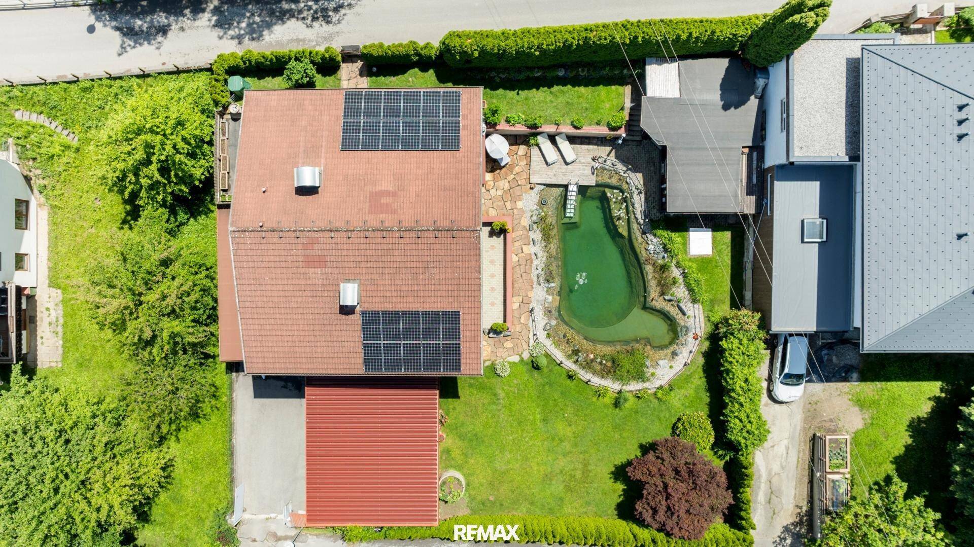 Vogelperspektive des Hauses mit Garten, Naturteich und Photovoltaikanlage auf dem Dach.