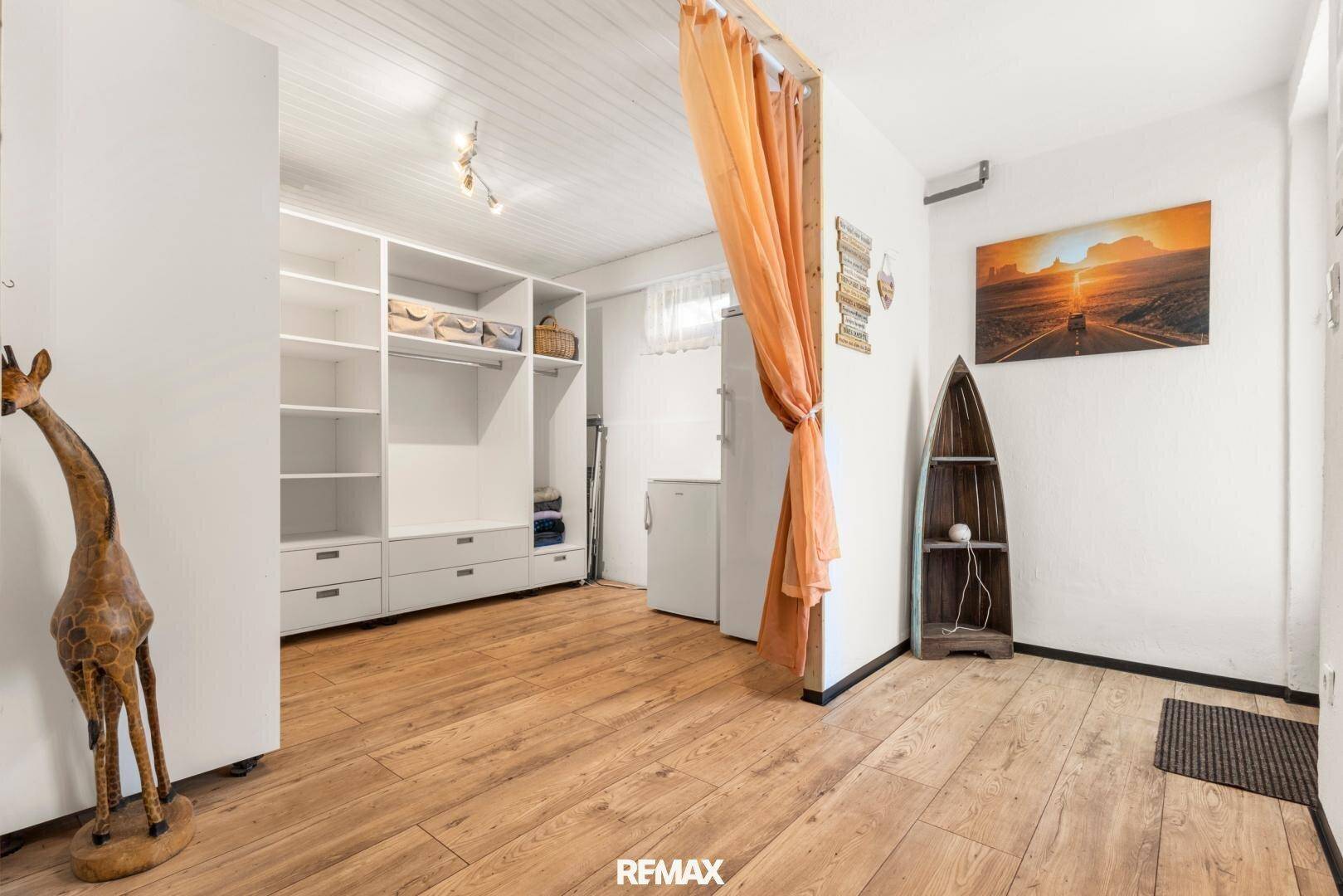 Praktischer Abstellraum mit Regalsystem, Kühlschrank und Holzfußboden.