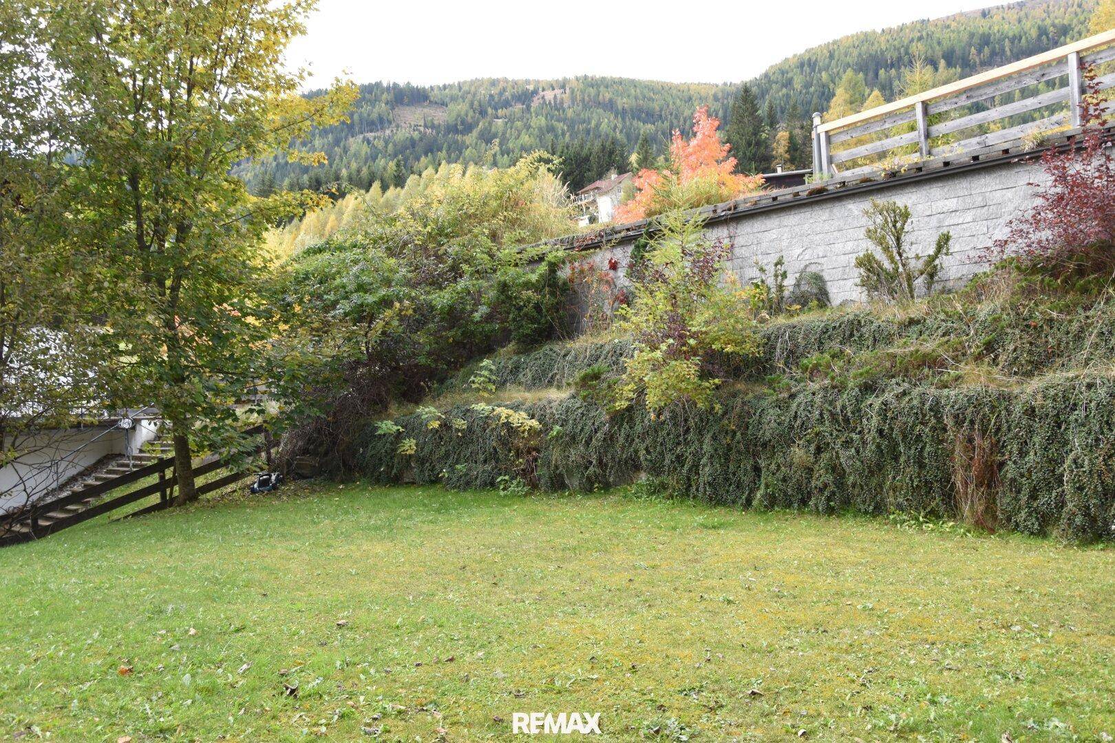 Terrassierter Gartenbereich mit üppiger Vegetation und Blick auf die umliegende Berglandschaft.