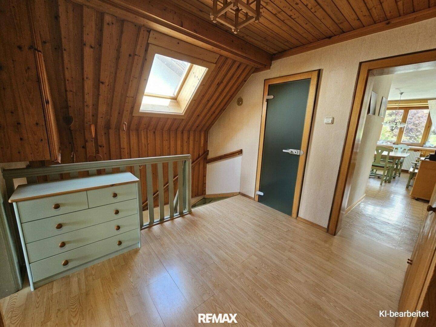 Flur mit Holzvertäfelung, Dachfenster und Treppenaufgang.