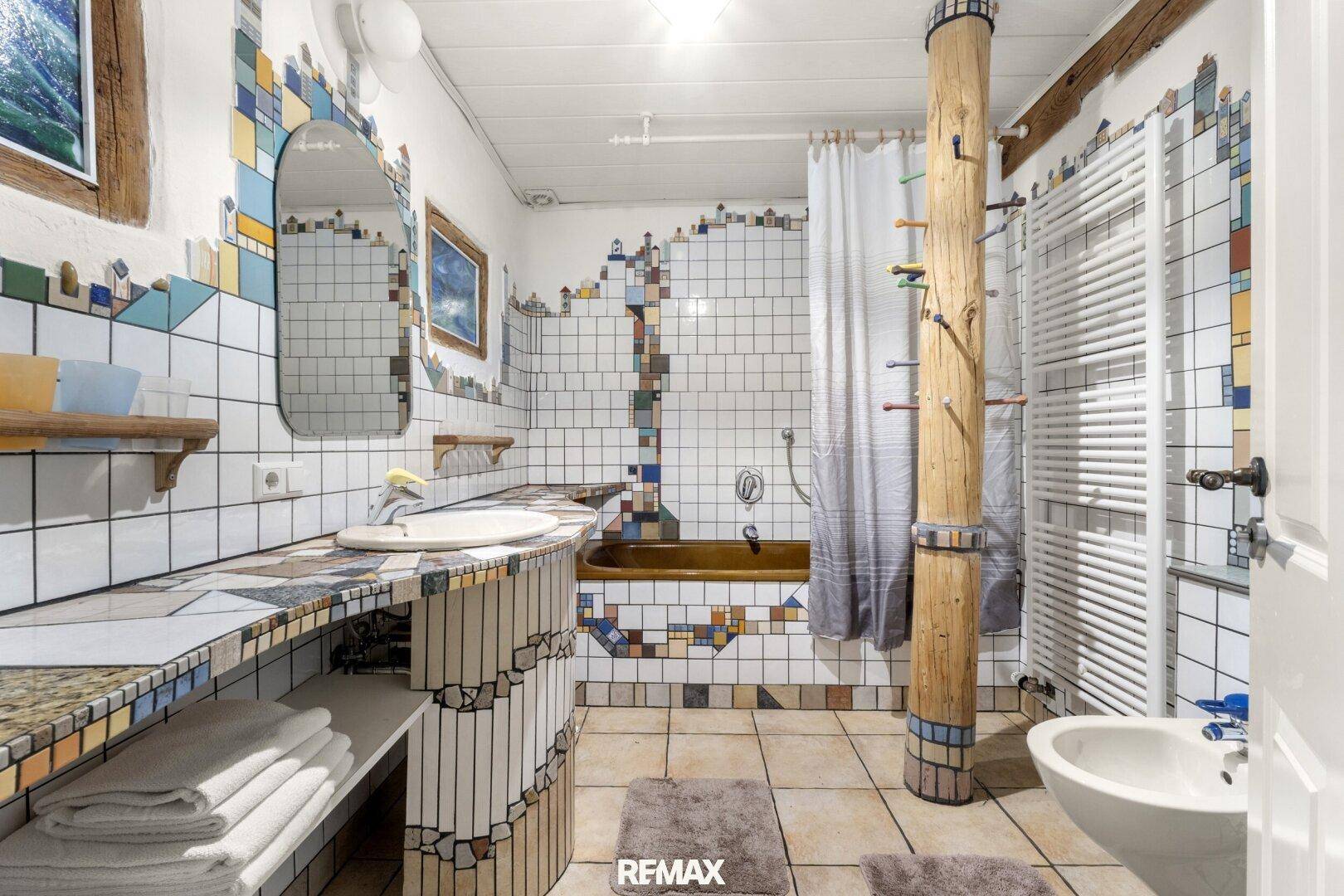 Farbenfrohes Badezimmer mit einzigartigen Fliesenmustern, Badewanne und Bidet.