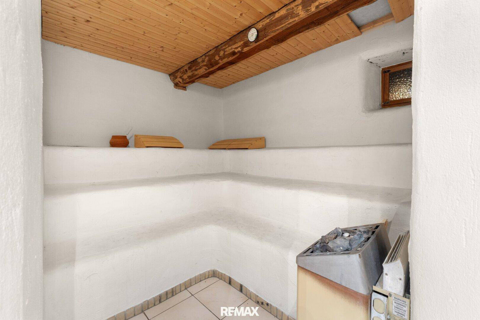 Gemütlicher Saunaraum mit Holzbänken, Holzdecke und einem Saunaofen für entspannende Momente.