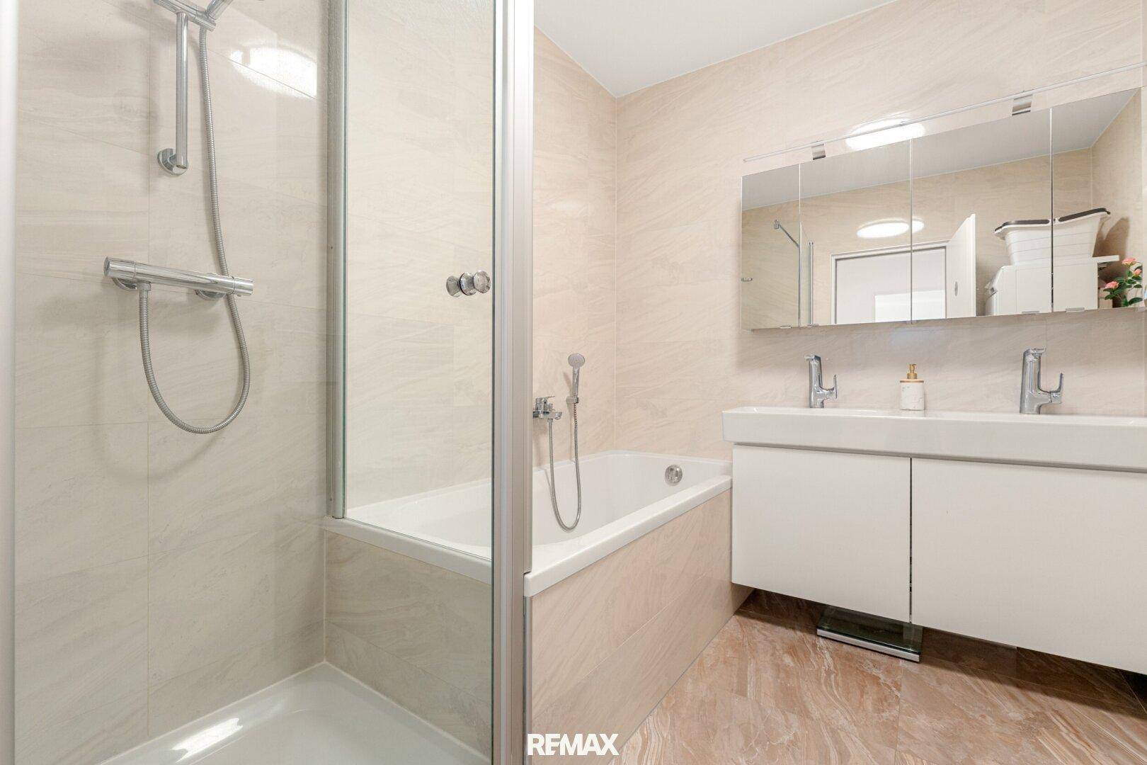 Modernes Badezimmer mit Doppelwaschbecken, Badewanne und separater Dusche.