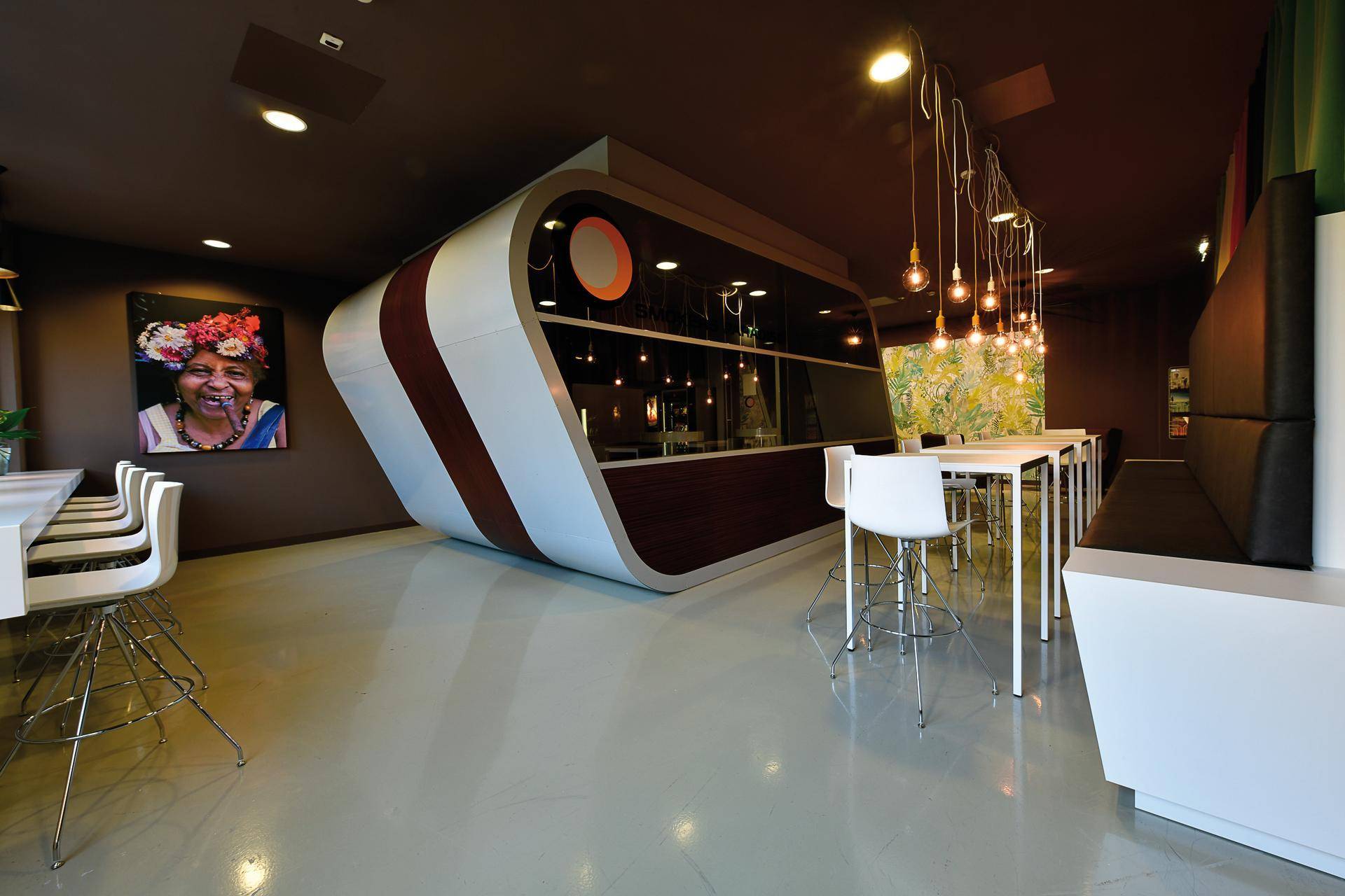 Futuristische Lounge mit geschwungener Theke, langen Tischen und stimmungsvoller Beleuchtung.