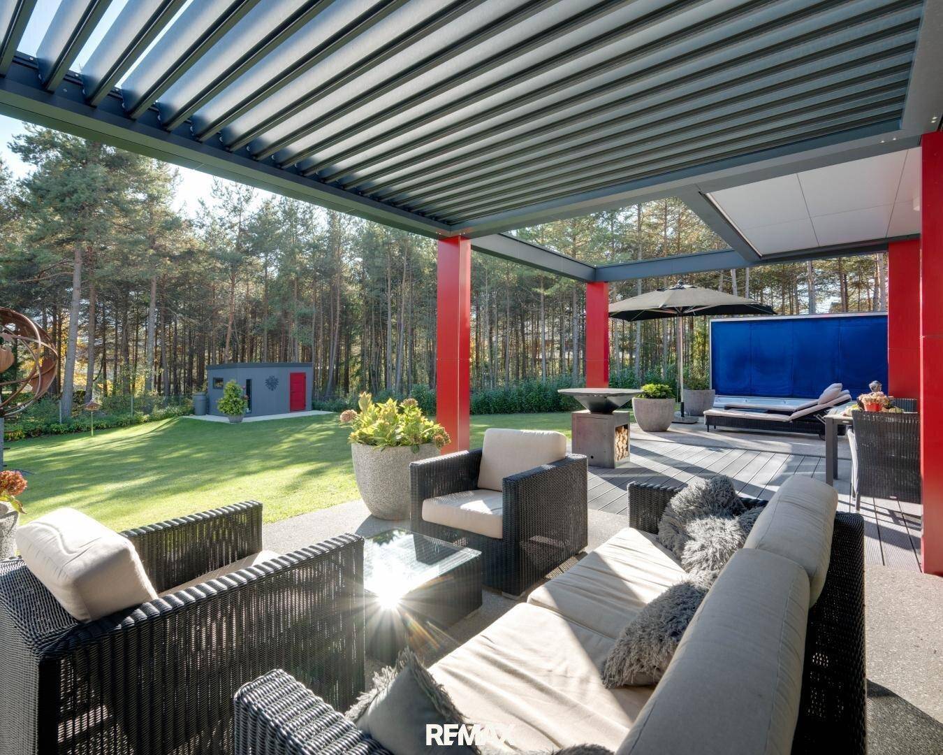 Überdachte Terrasse mit bequemen Loungemöbeln, ideal für entspannte Stunden im Freien.