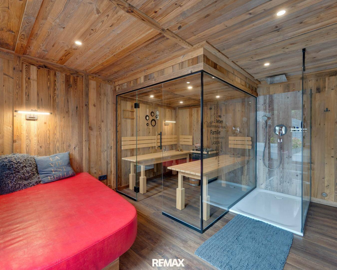 Gemütlicher Wellnessbereich mit Holzverkleidung, integrierter Sauna und moderner Dusche.