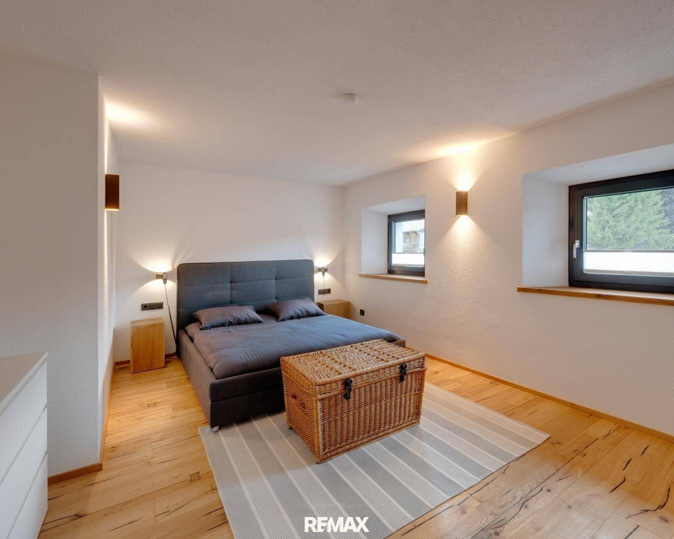 Gemütliches Schlafzimmer mit Doppelbett, Holzboden und indirekter Beleuchtung, bietet Ruhe.