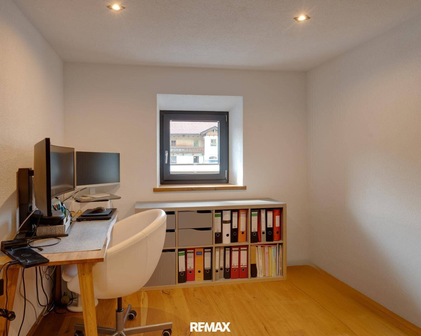 Funktionales Büro mit Schreibtisch, Computern und Regal, ideal für Home-Office-Arbeit.
