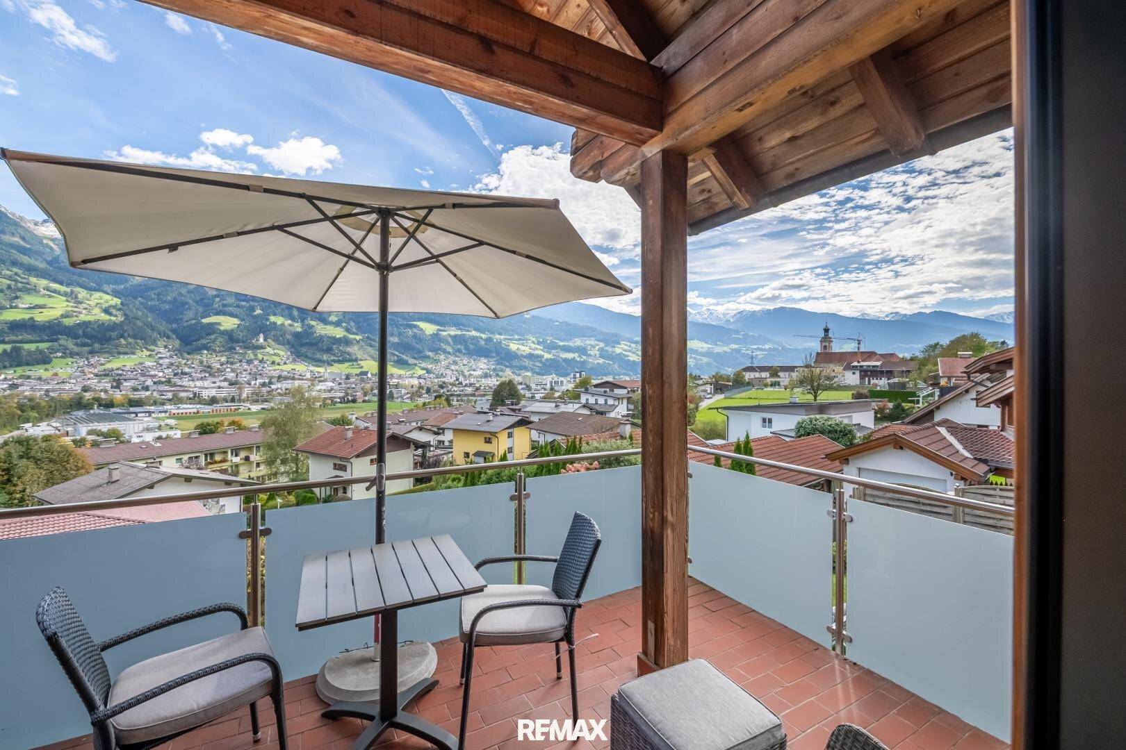 Geräumiger Balkon mit Sitzgelegenheiten und atemberaubendem Blick auf die Stadt und die umliegenden Berge.
