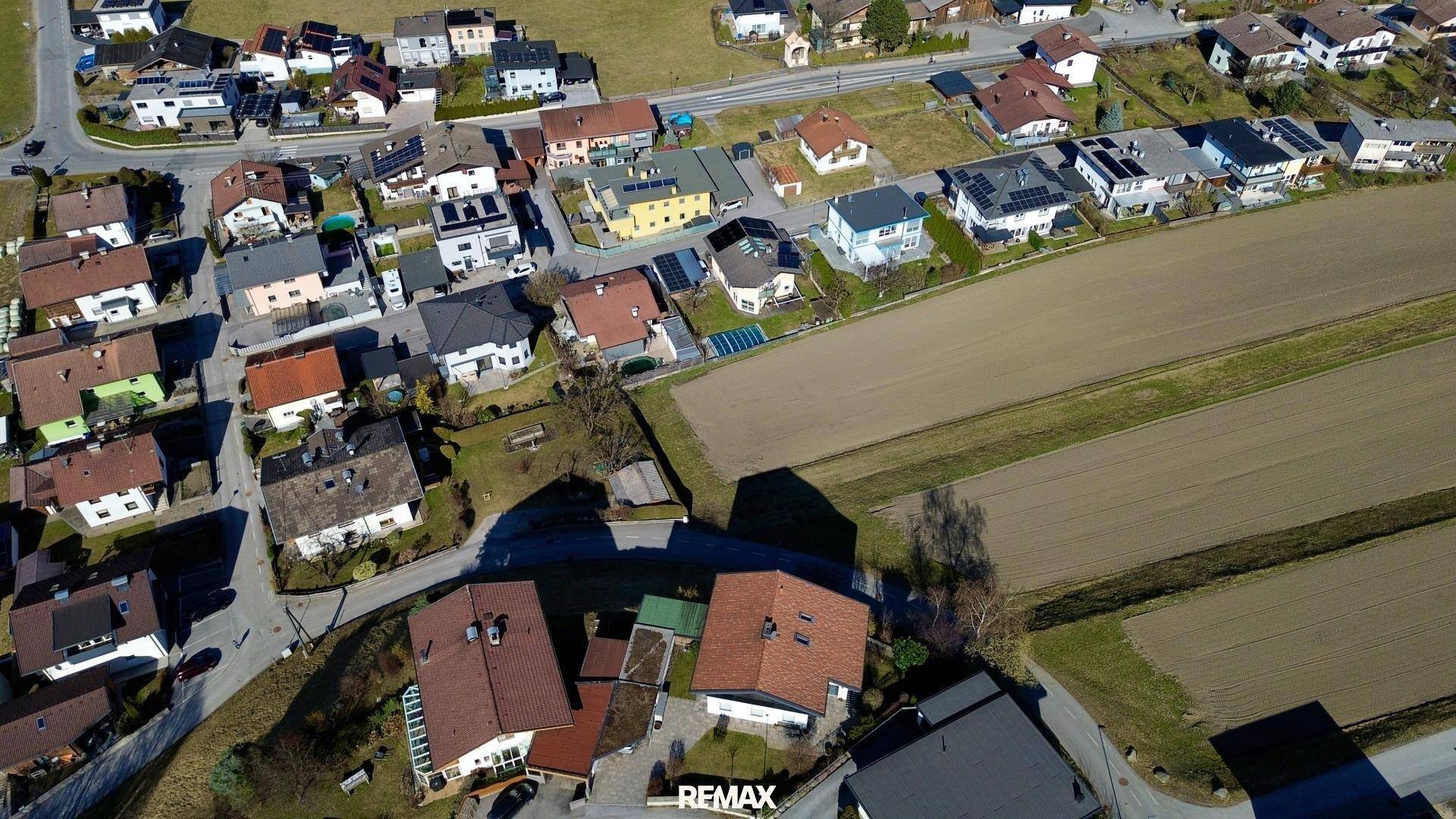 Überblick aus der Vogelperspektive über eine Wohngegend mit vielen Häusern und landwirtschaftlichen Flächen.