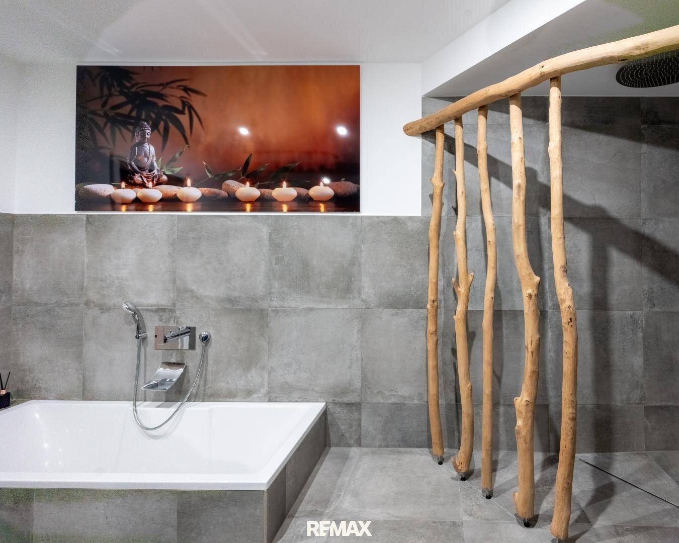 Elegantes Badezimmer mit Badewanne, Regendusche und modernen grauen Fliesen, dekoriert mit Naturholz.