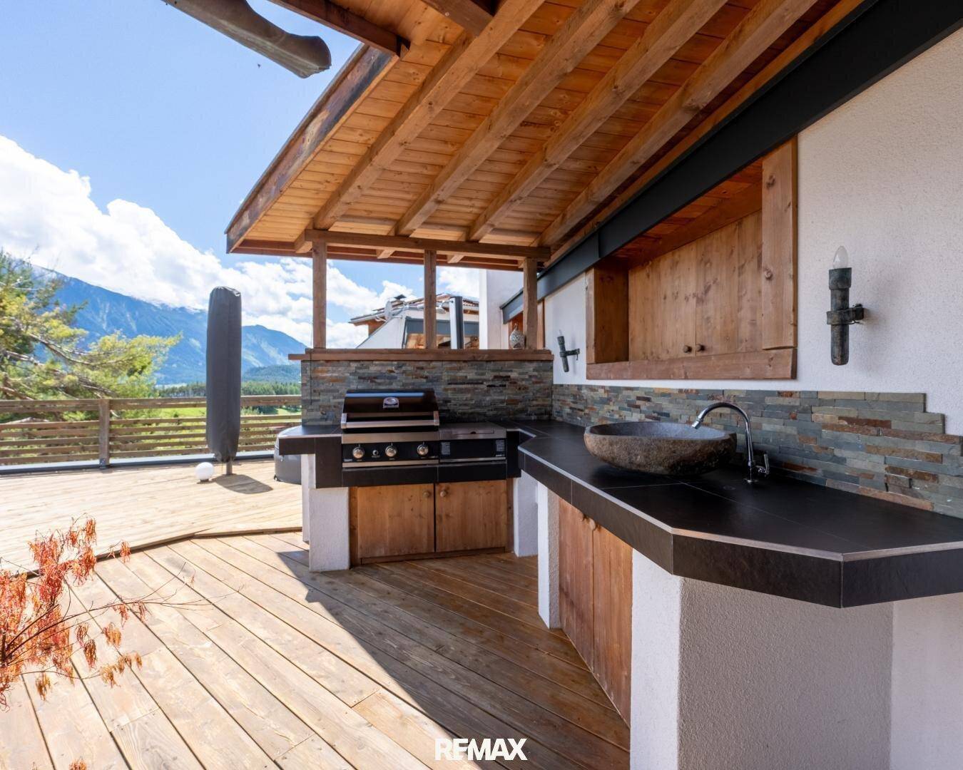 Detailansicht der Außenküche auf der Terrasse mit Grill, Spülbecken und Arbeitsflächen.