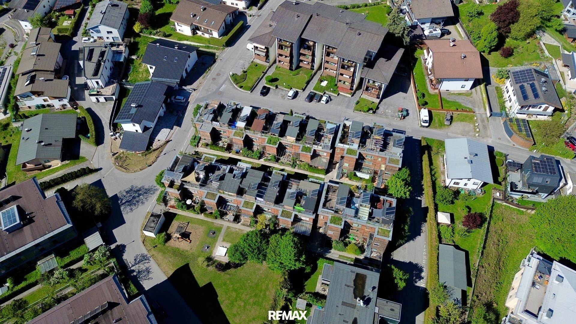 Luftaufnahme der Wohnanlage und der umliegenden Nachbarschaft mit viel Grün.