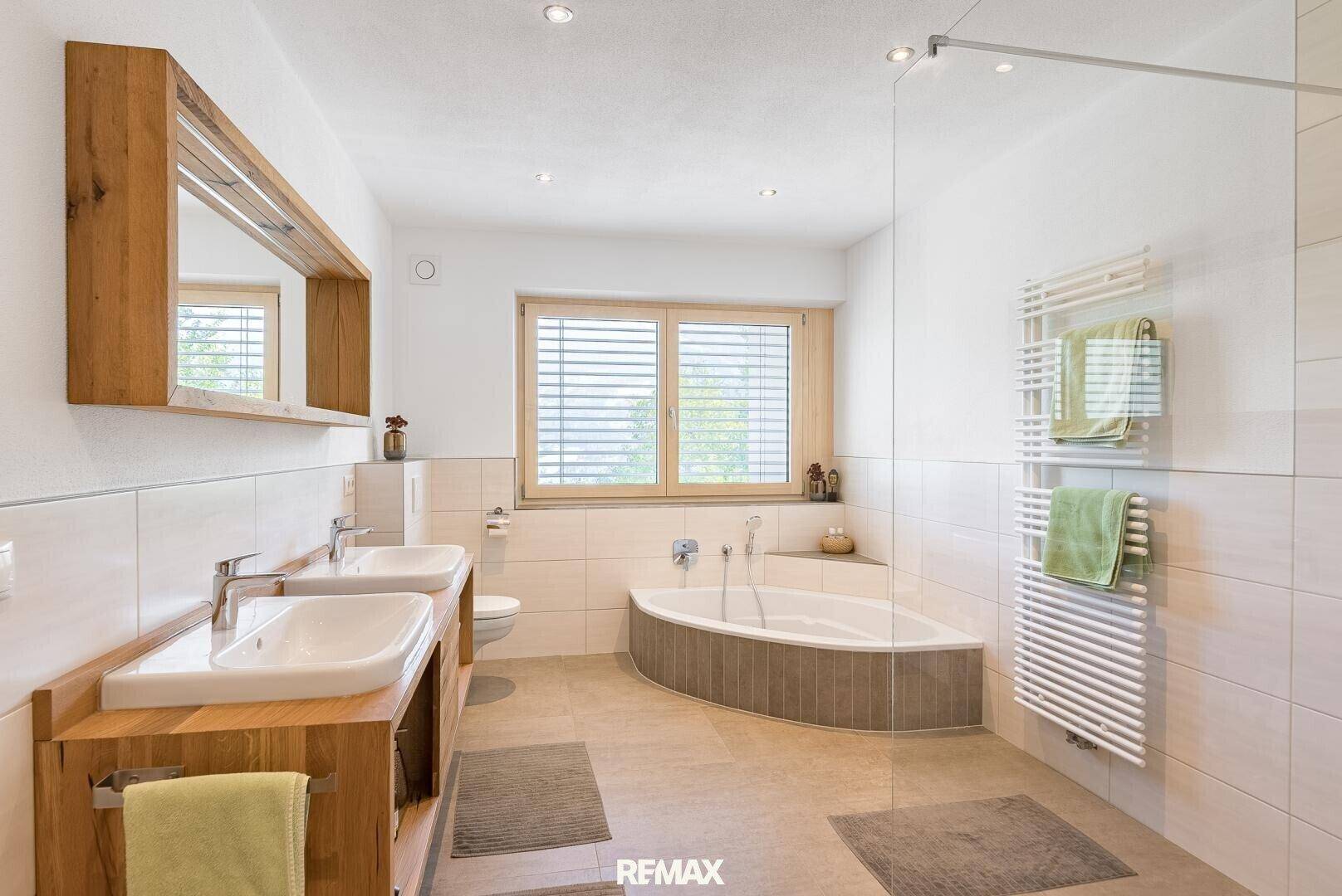 Modernes Badezimmer mit Doppelwaschbecken, Eckbadewanne und separater Dusche.