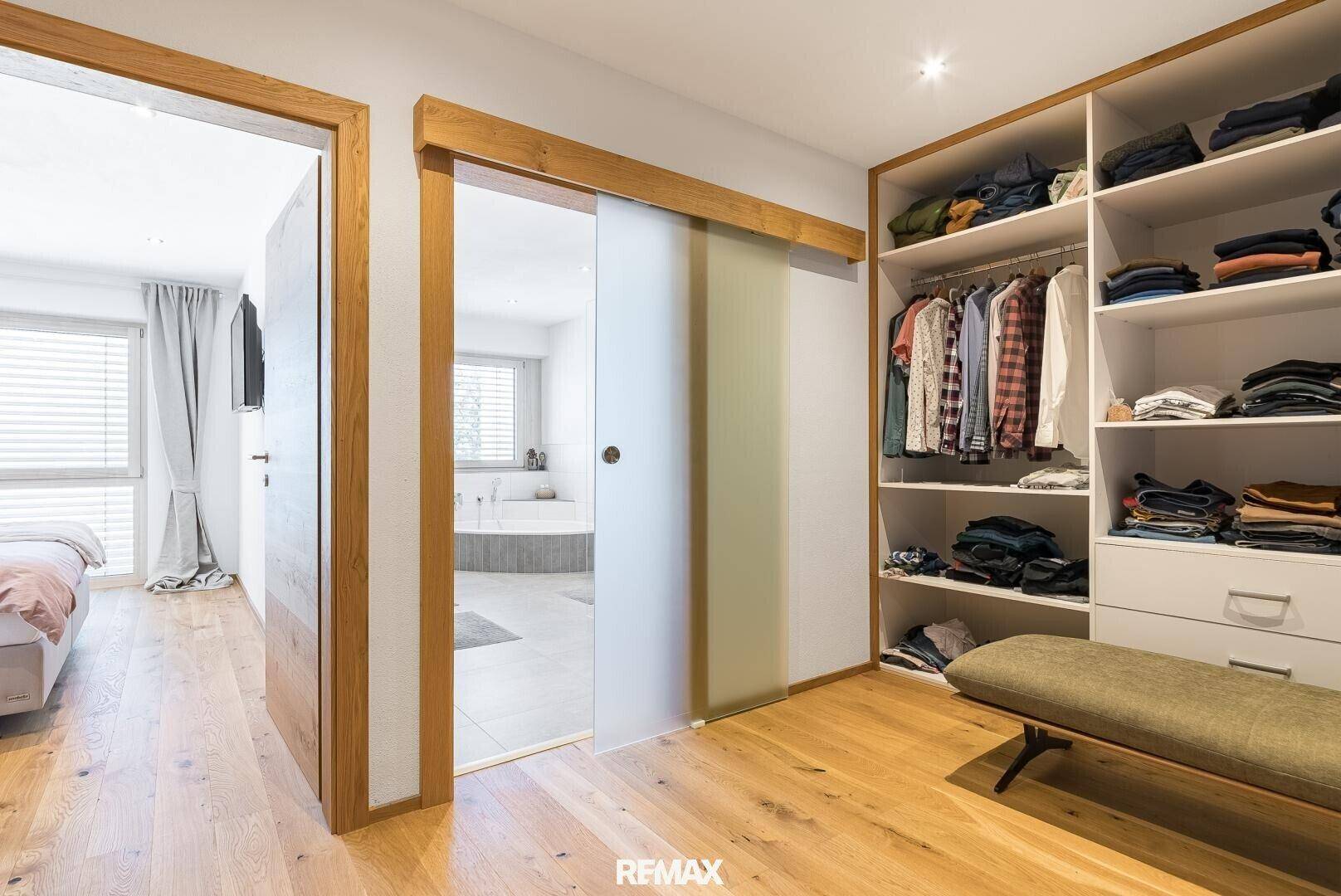 Praktischer begehbarer Kleiderschrank mit viel Stauraum und Zugang zum Badezimmer.