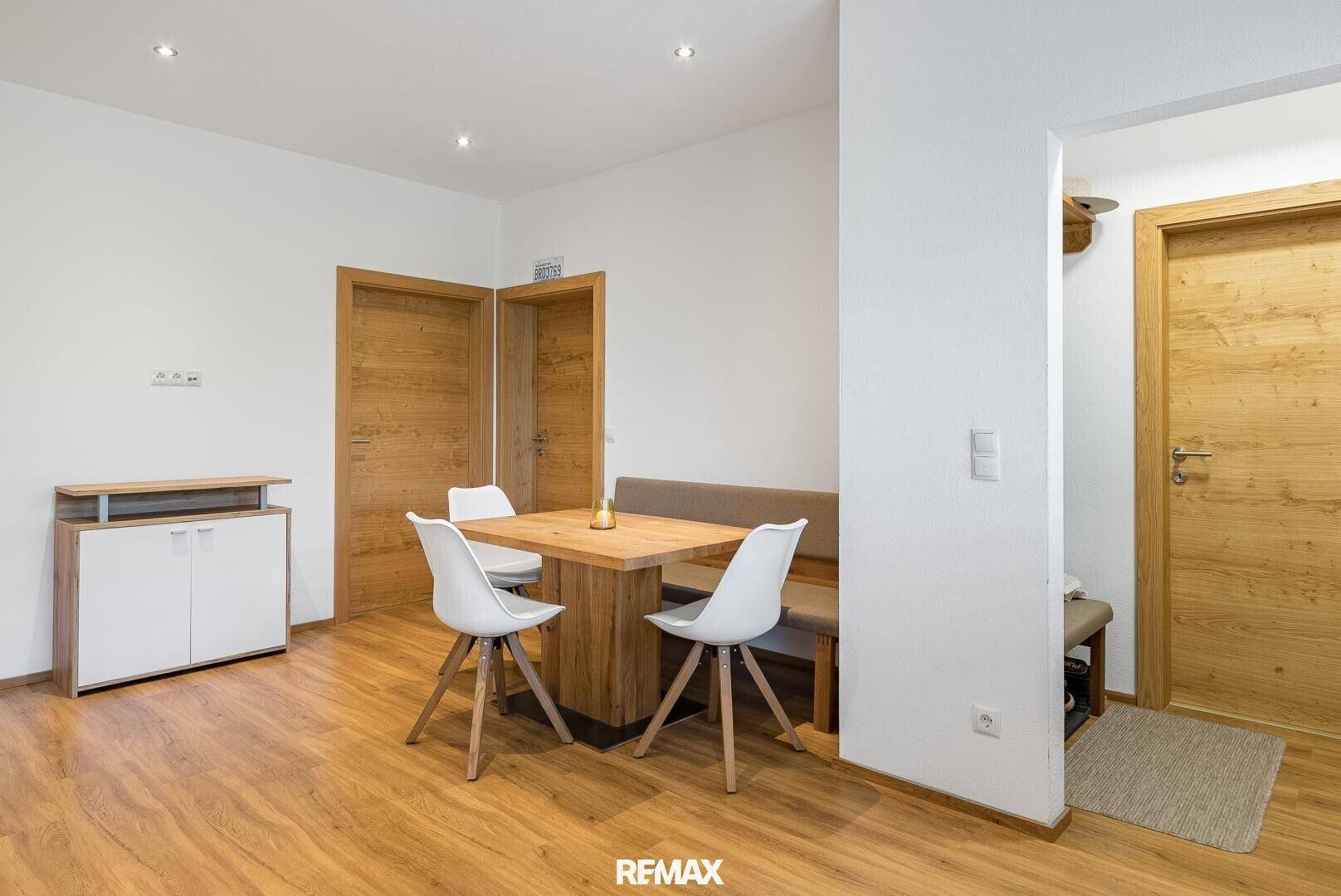 Heller Essbereich mit Holztisch und modernen weißen Stühlen.