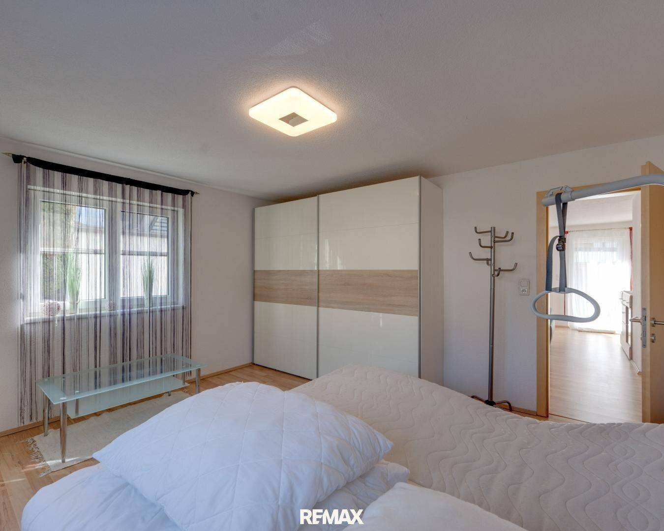 Schlafzimmer mit großem Kleiderschrank, hellem Holzfußboden und Fenster für natürliches Licht.