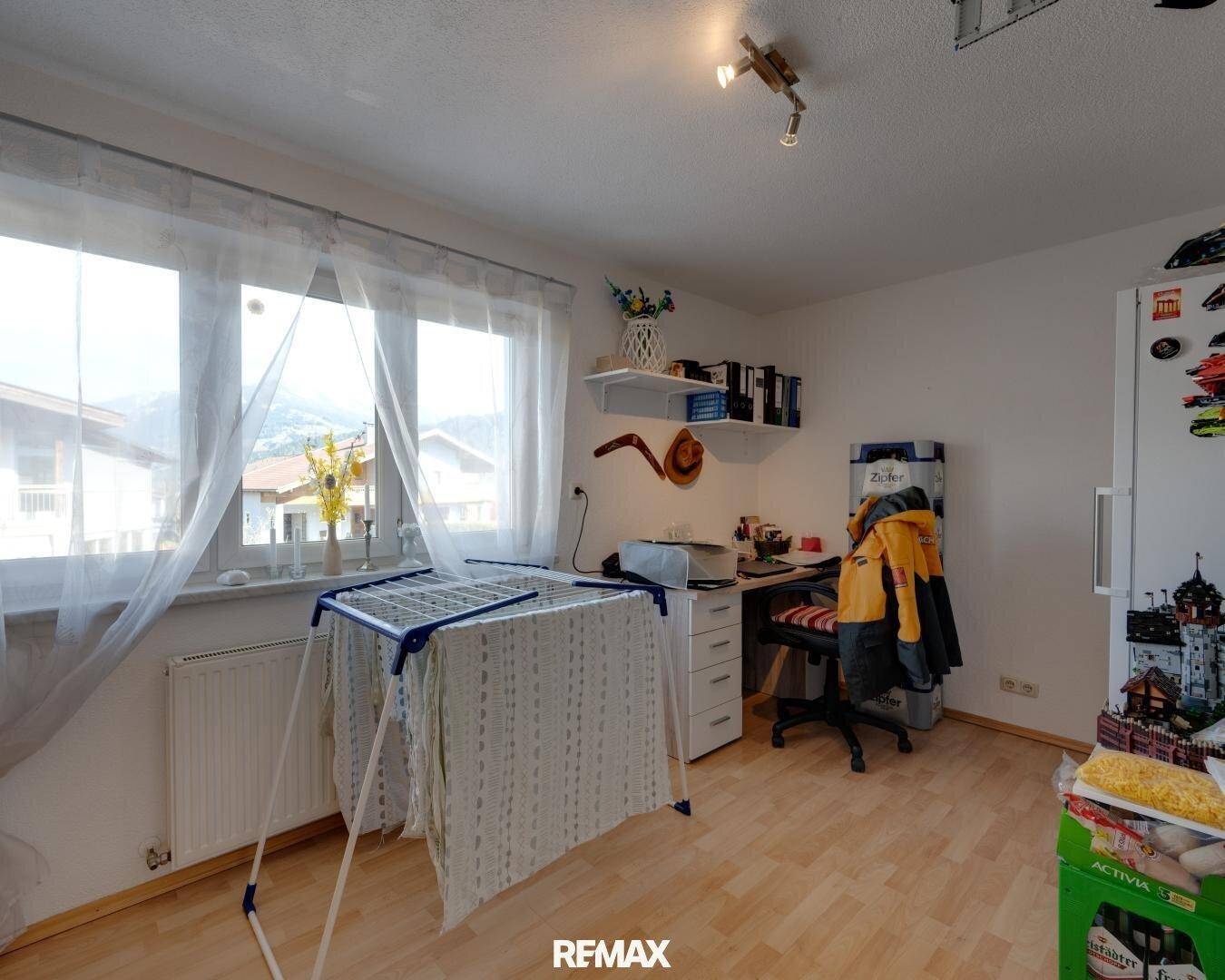 Vielseitiger Raum, genutzt als Büro mit Schreibtisch und Fenster mit Bergblick.