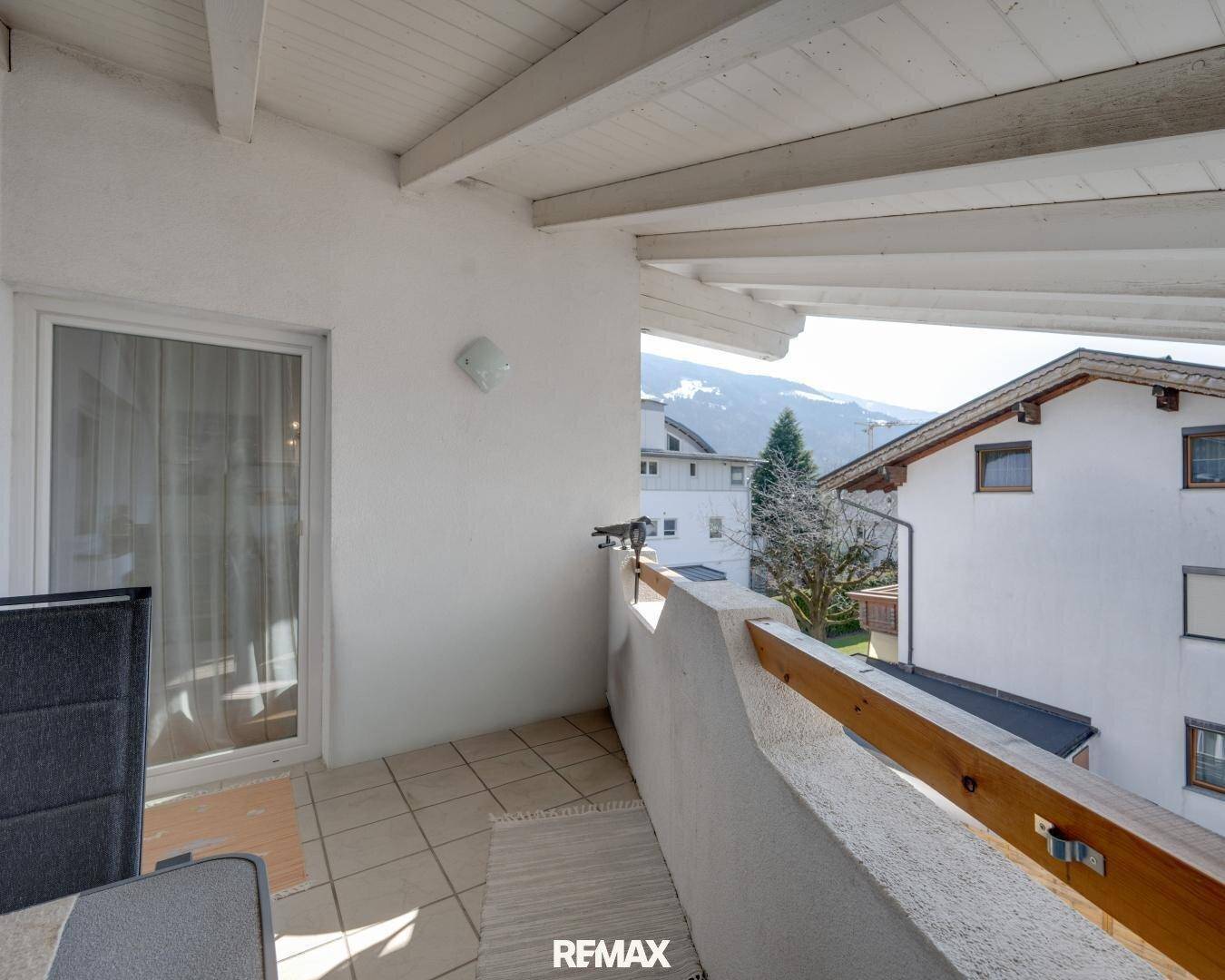Überdachter Balkon mit Fliesenboden und herrlichem Blick auf die umliegende Berglandschaft.