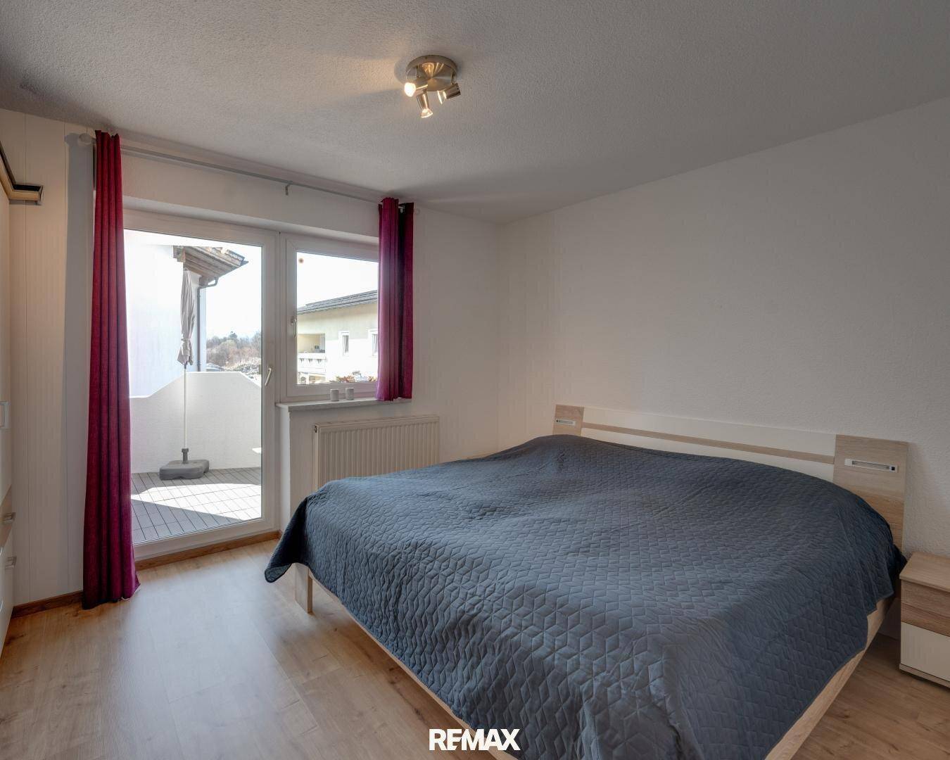 Schlafzimmer mit Zugang zu einem sonnigen Balkon, ausgestattet mit einem Doppelbett.